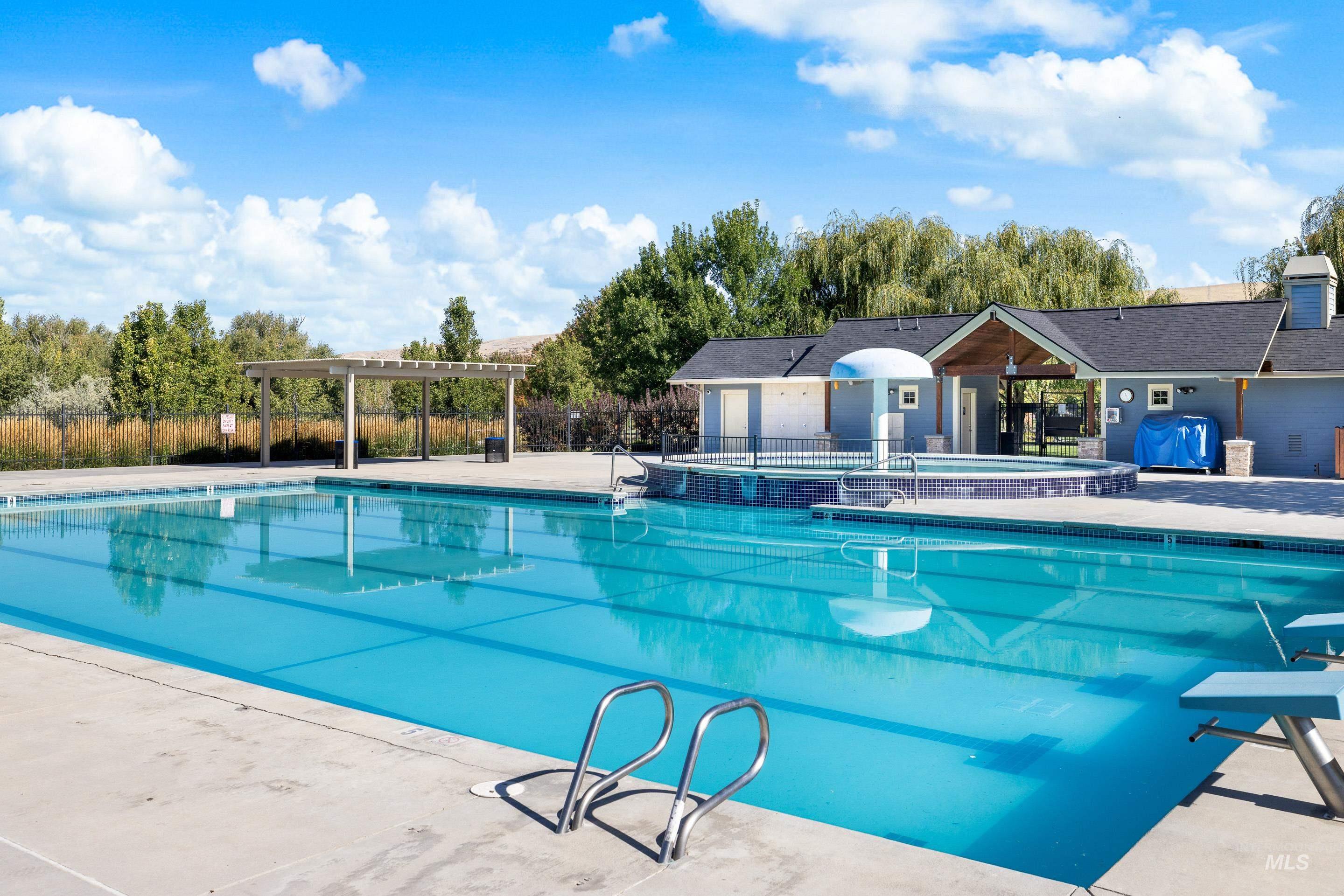 Community pool featuring a patio, a diving board, and a pergola