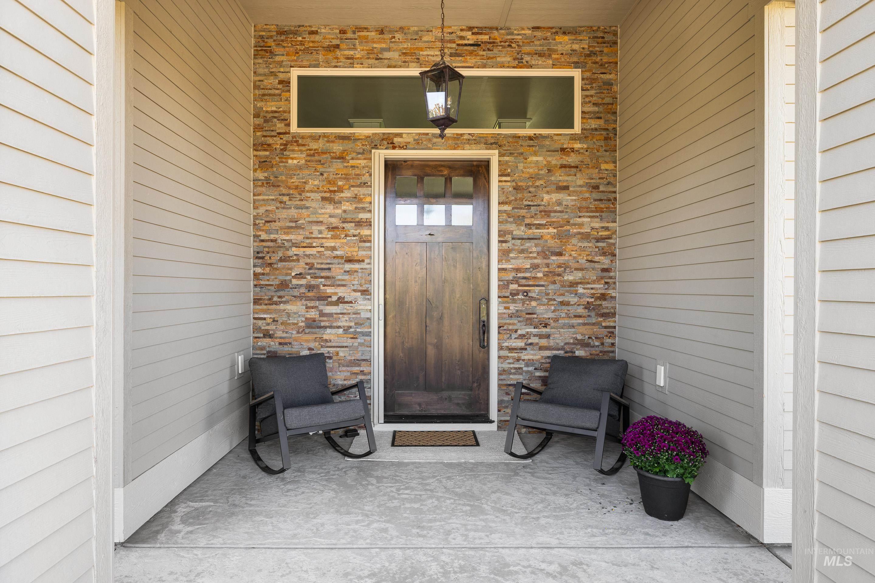 Entrance to property with brick siding and a patio