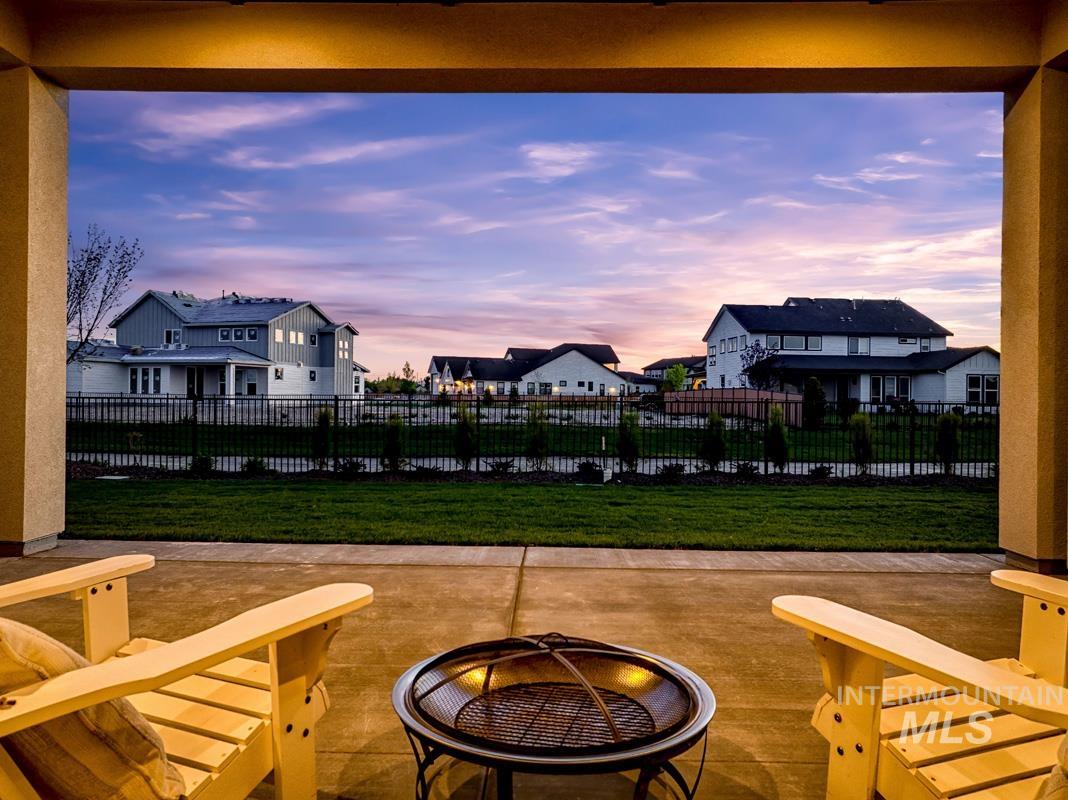 Patio terrace at dusk featuring a patio, a residential view, and a fire pit