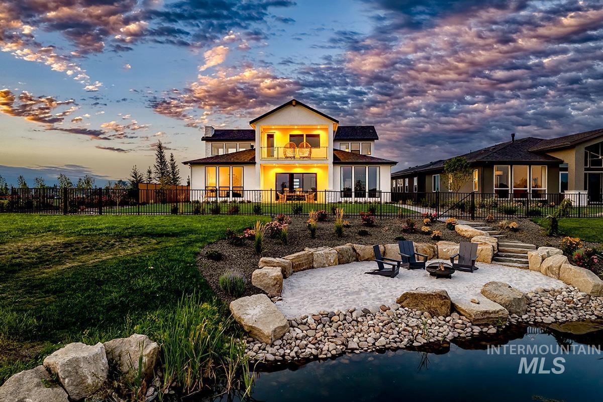 Back of property featuring a patio area, a fire pit, a fenced backyard, and a balcony