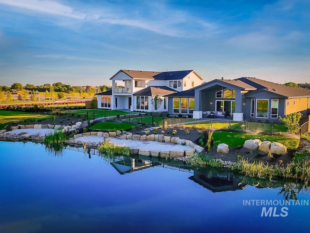 Back of property featuring a patio area, a balcony, and a water view