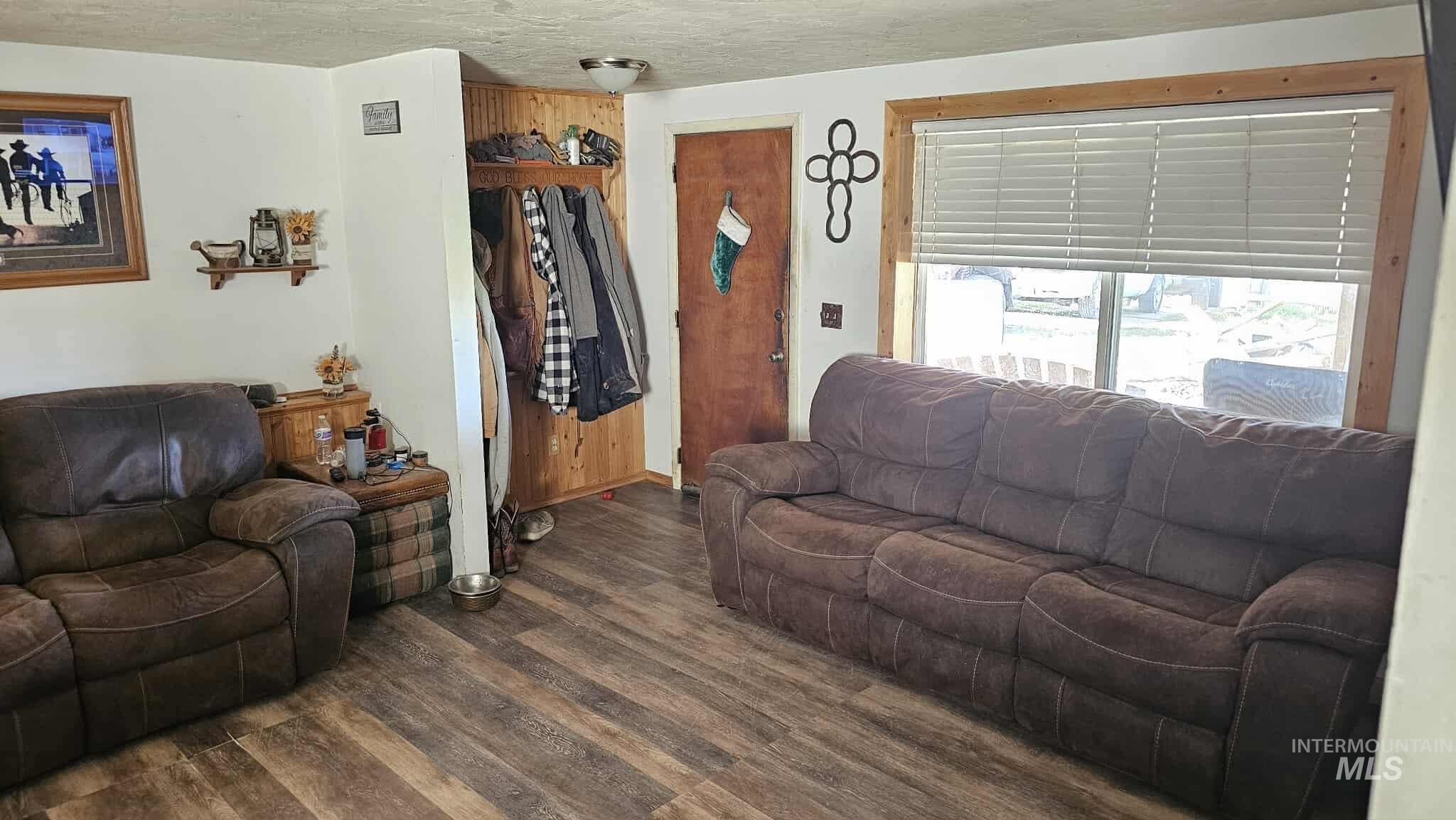 Living area featuring dark wood-style flooring and a textured ceiling