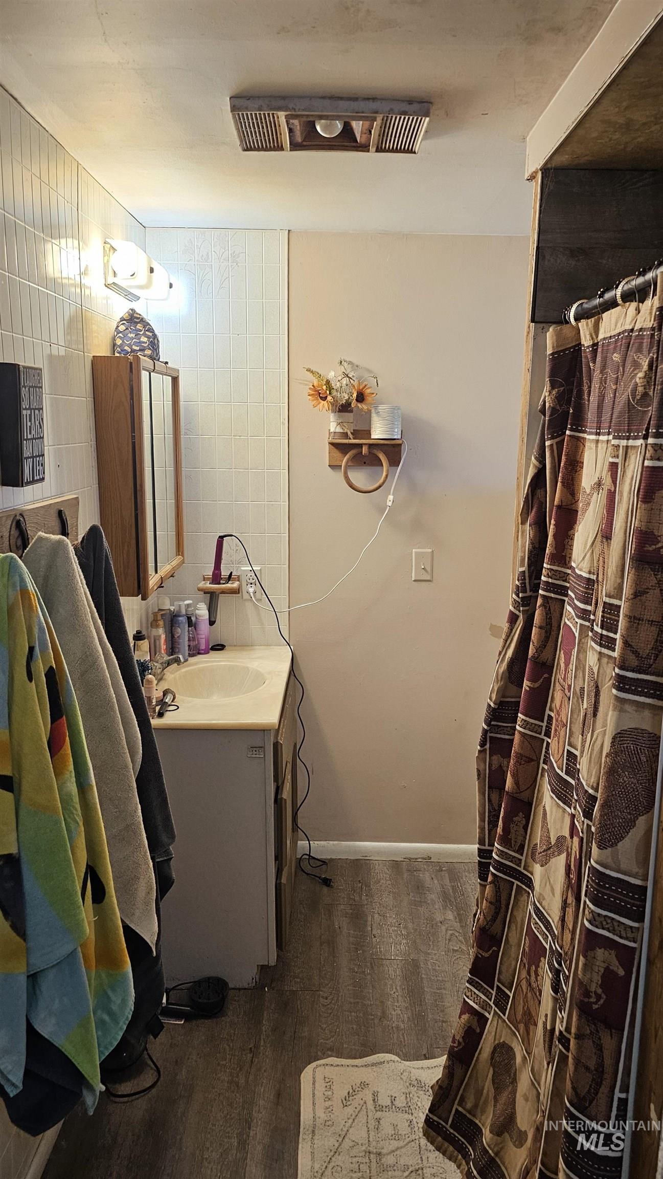 Full bathroom with vanity, dark wood finished floors, and a shower with curtain