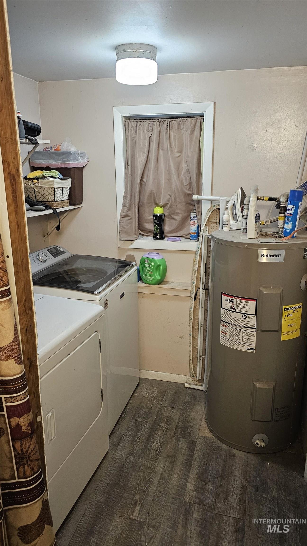 Washroom with dark wood-style floors, water heater, and washing machine and clothes dryer