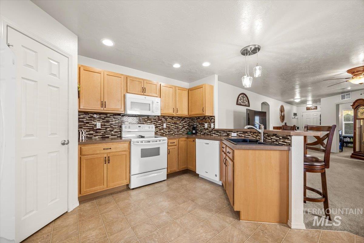 Modern kitchen with ample storage and stylish backsplash.