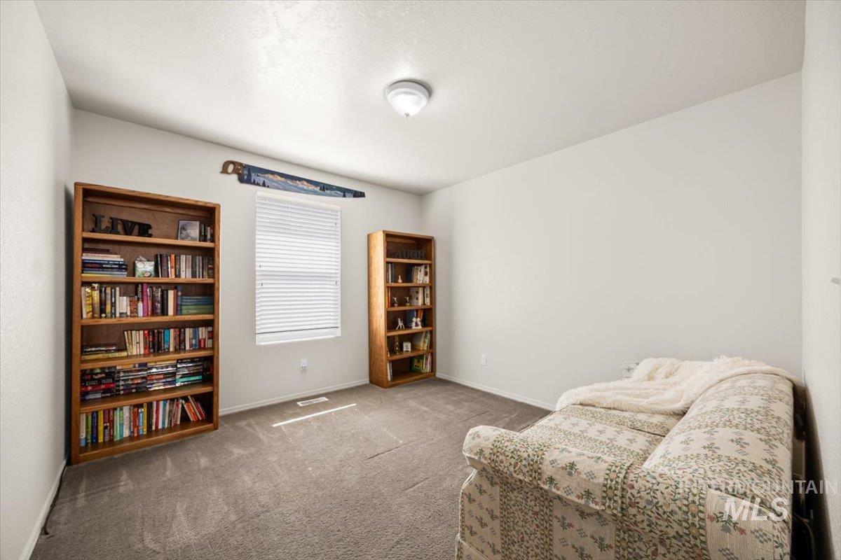 2nd bedroom used as a cozy reading room/ library with natural light.