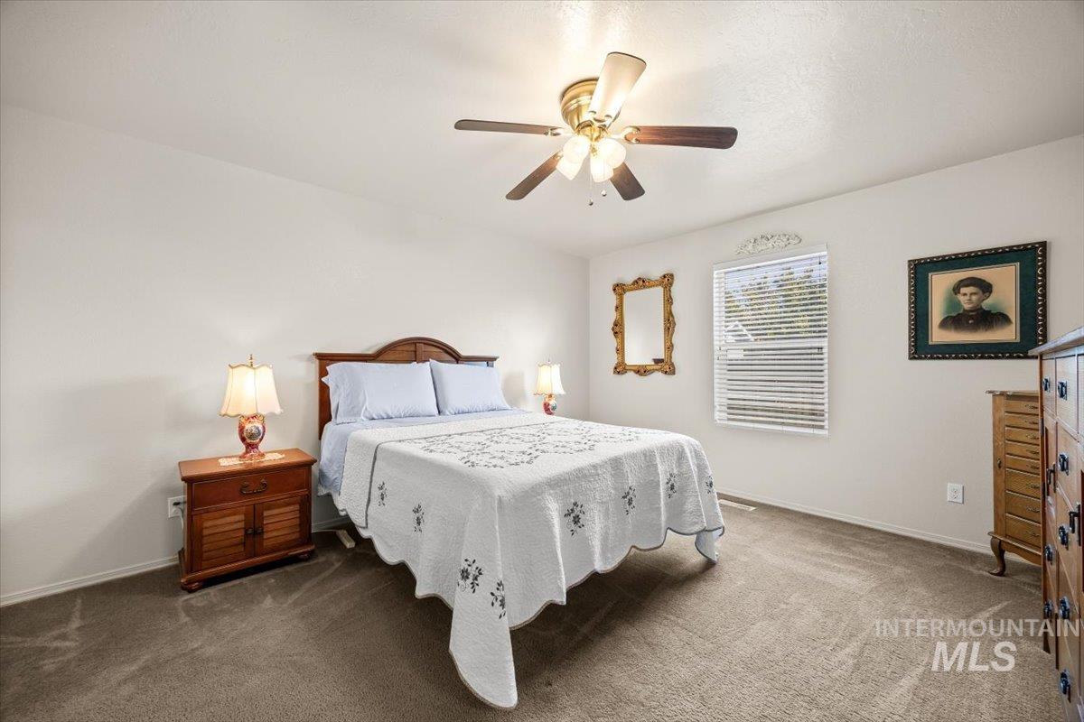 Peaceful primary bedroom with ensuite and ceiling fan.