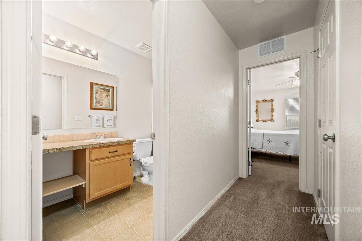 Bright hallway leads to a cozy bedroom and a modern bathroom.