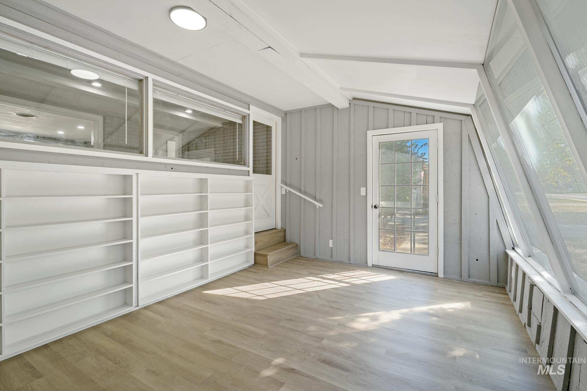 Doorway to outside featuring wood finished floors and stairway