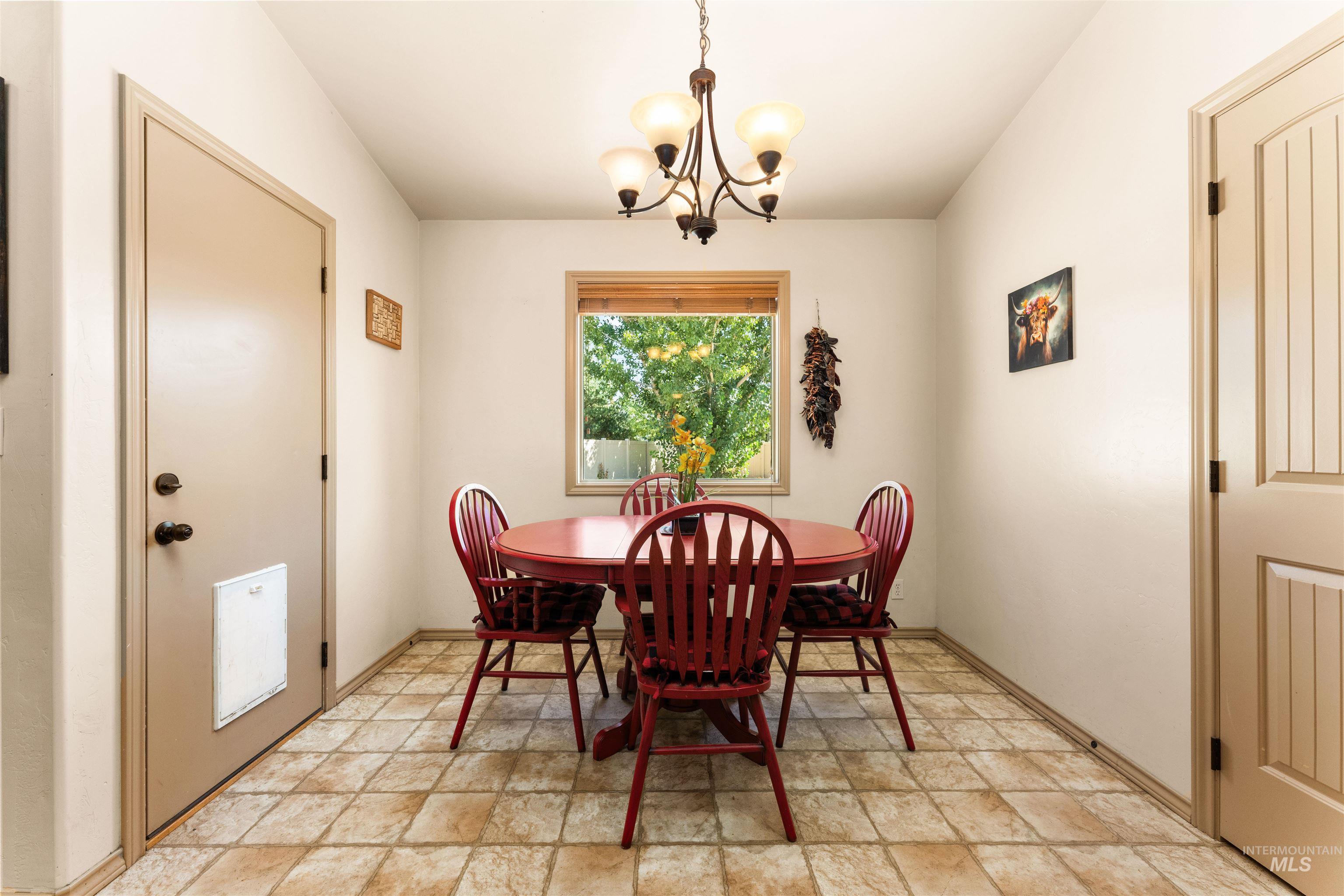 Dining space with stone finish flooring and a chandelier