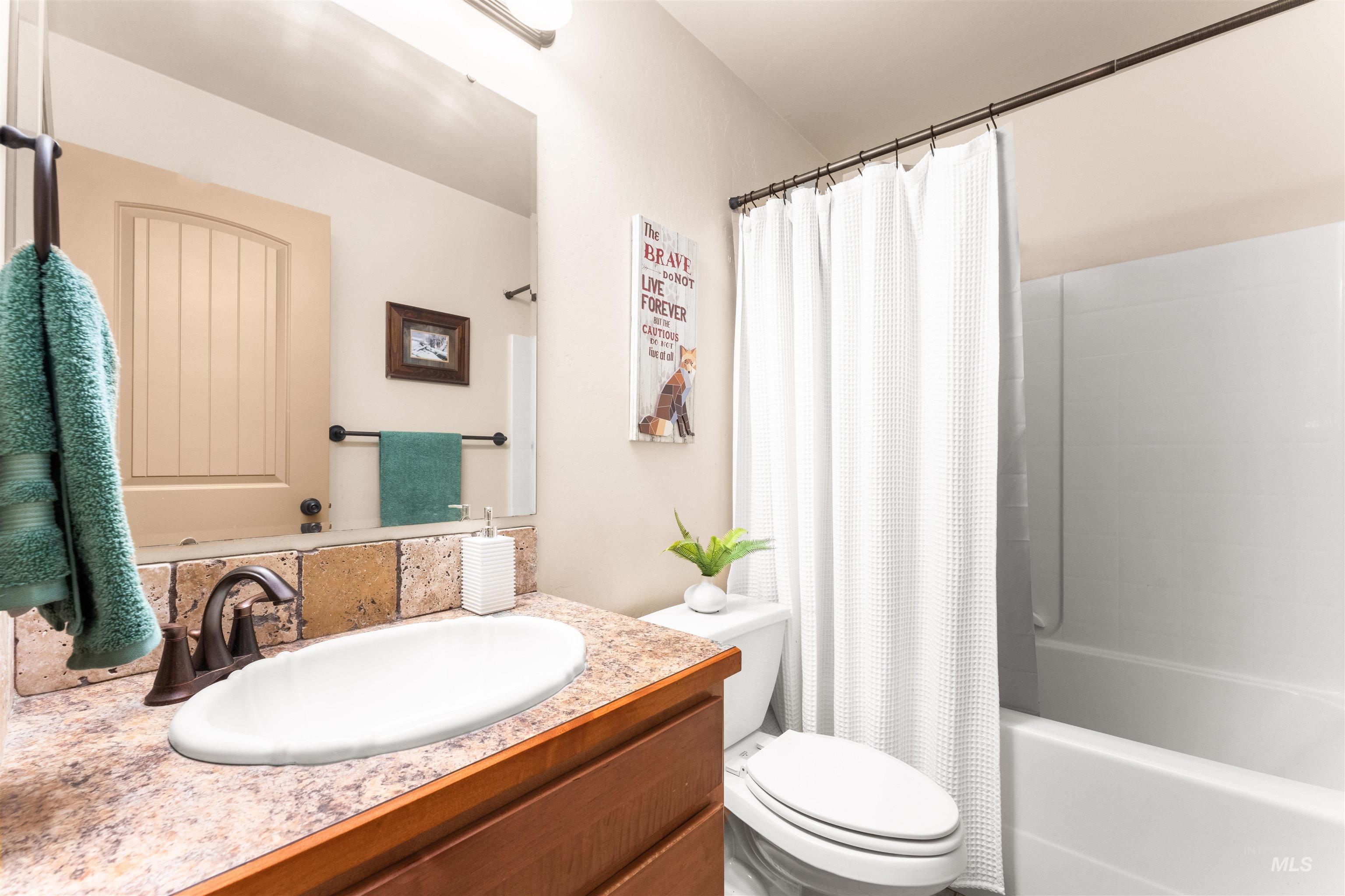 Full bathroom with shower / bath combination with curtain and vanity