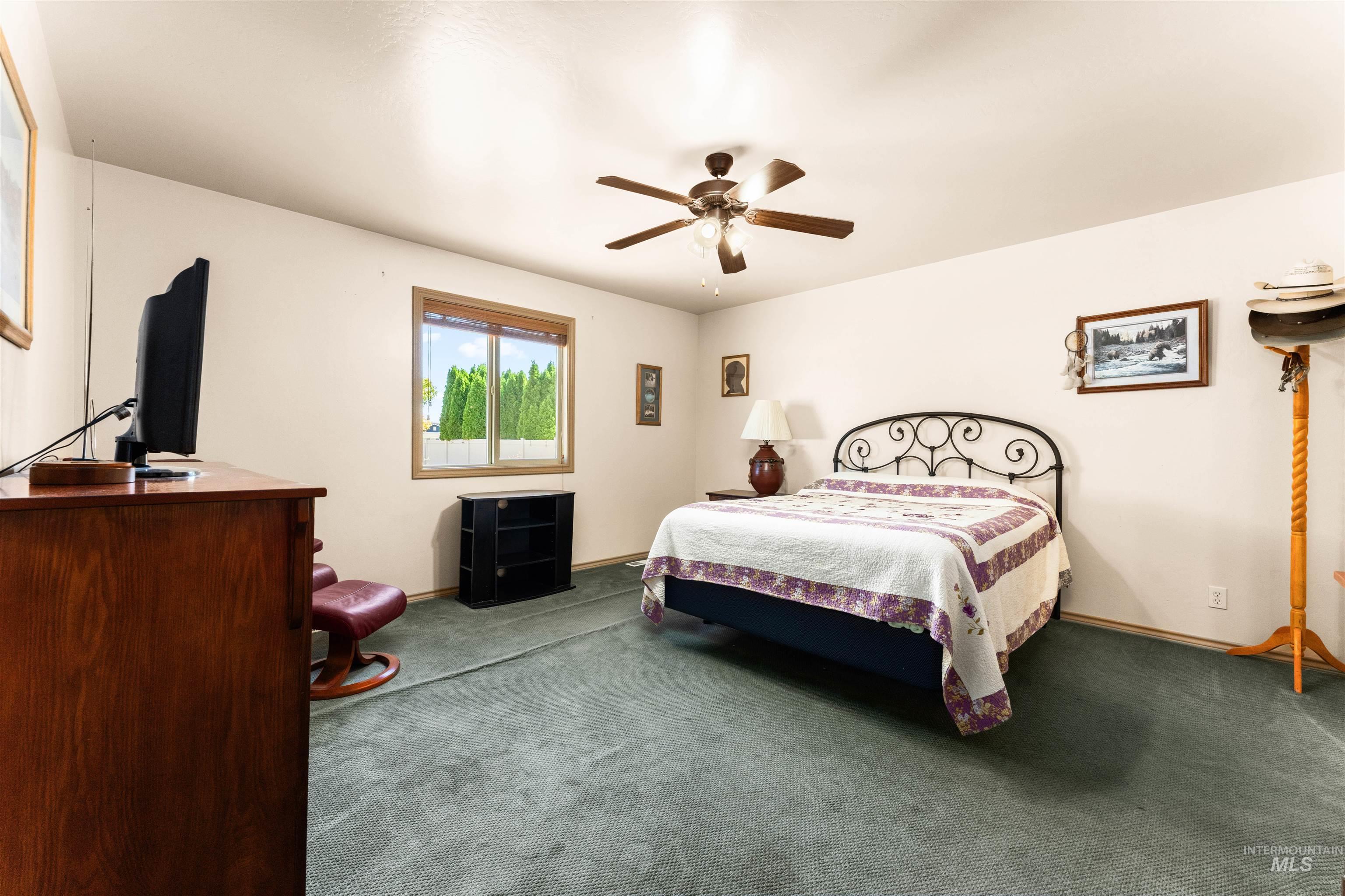 Bedroom with ceiling fan and carpet