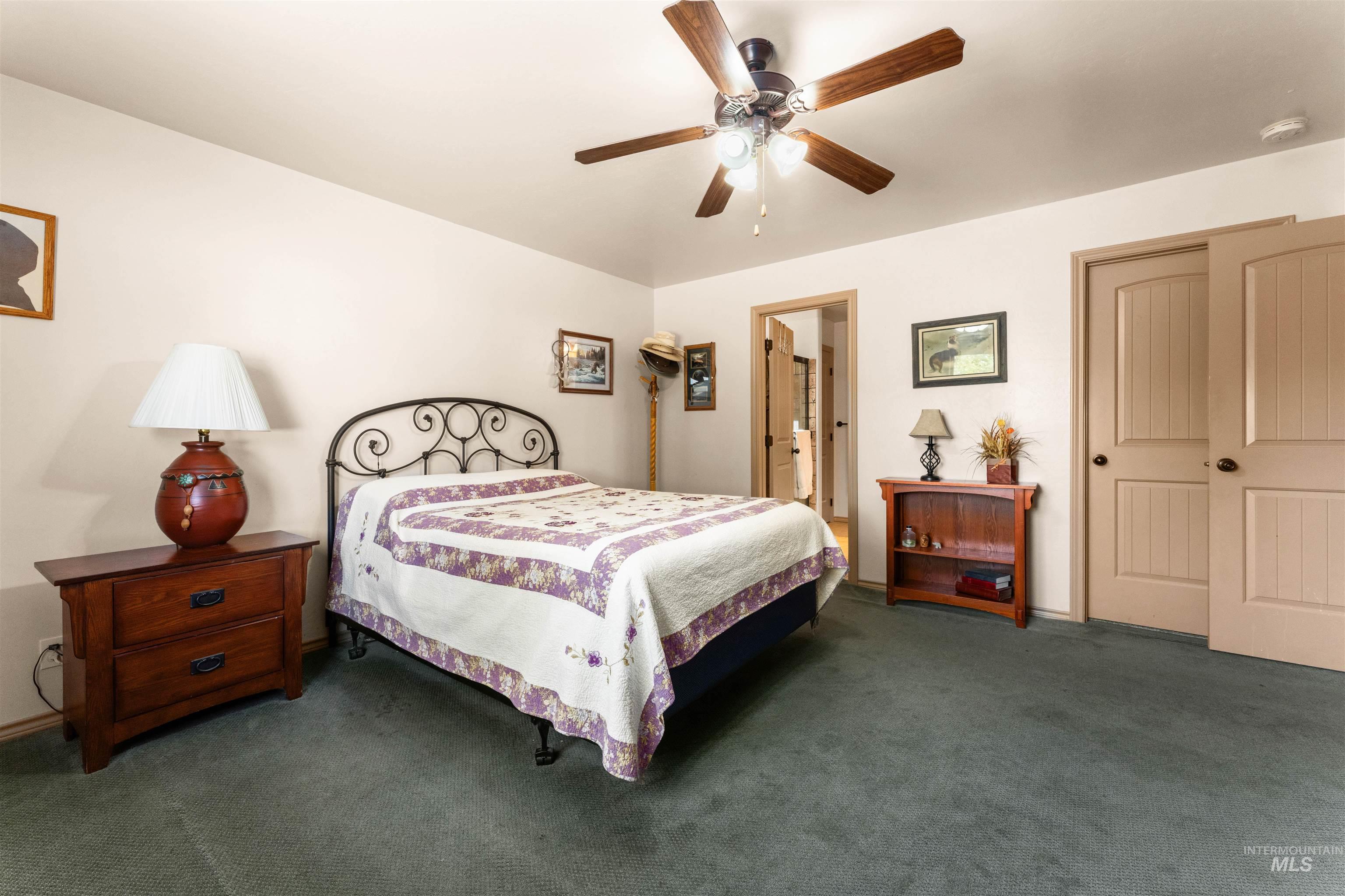 Bedroom with dark carpet and ceiling fan
