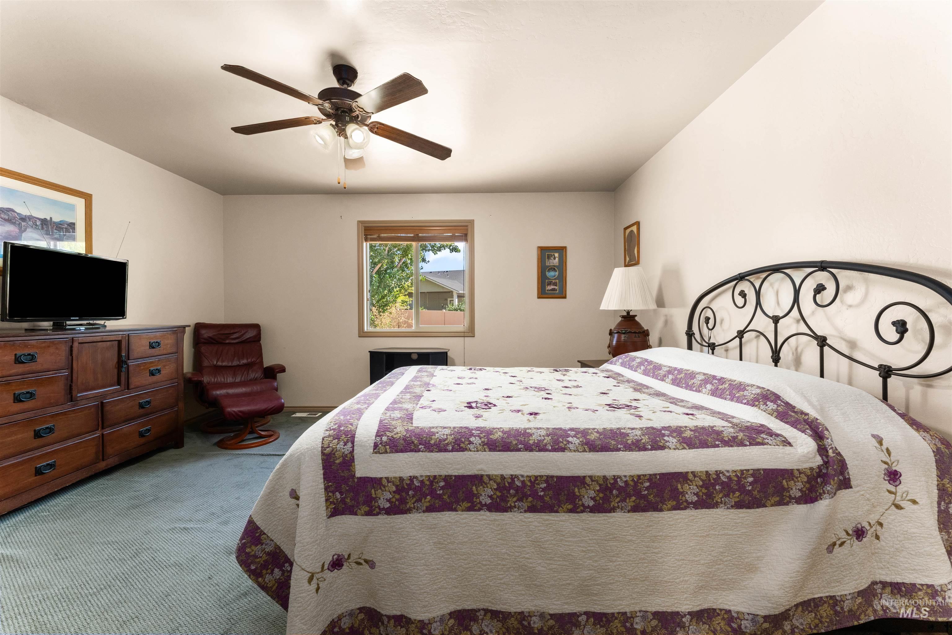 Bedroom featuring ceiling fan and carpet floors