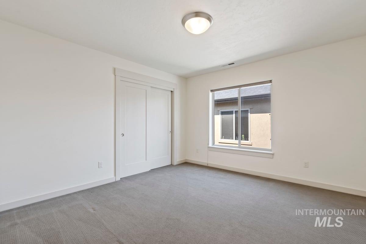Unfurnished bedroom with light colored carpet and a closet