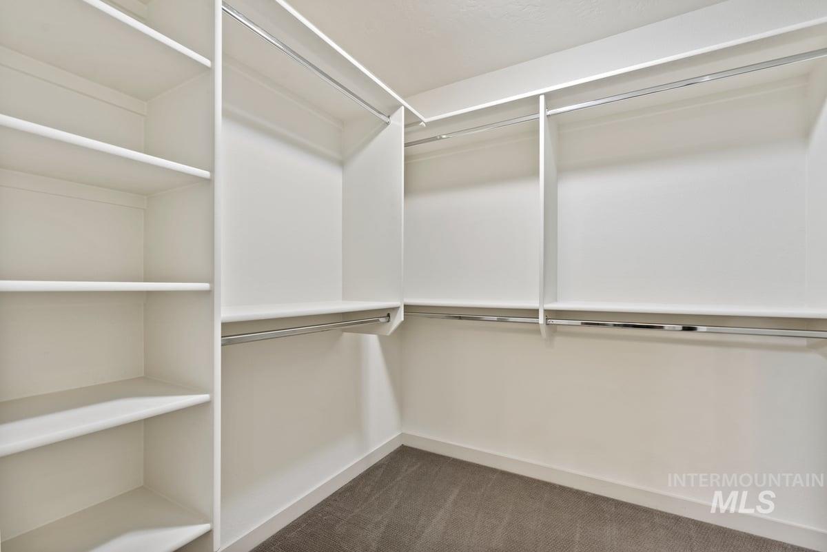 Walk in closet featuring dark carpet