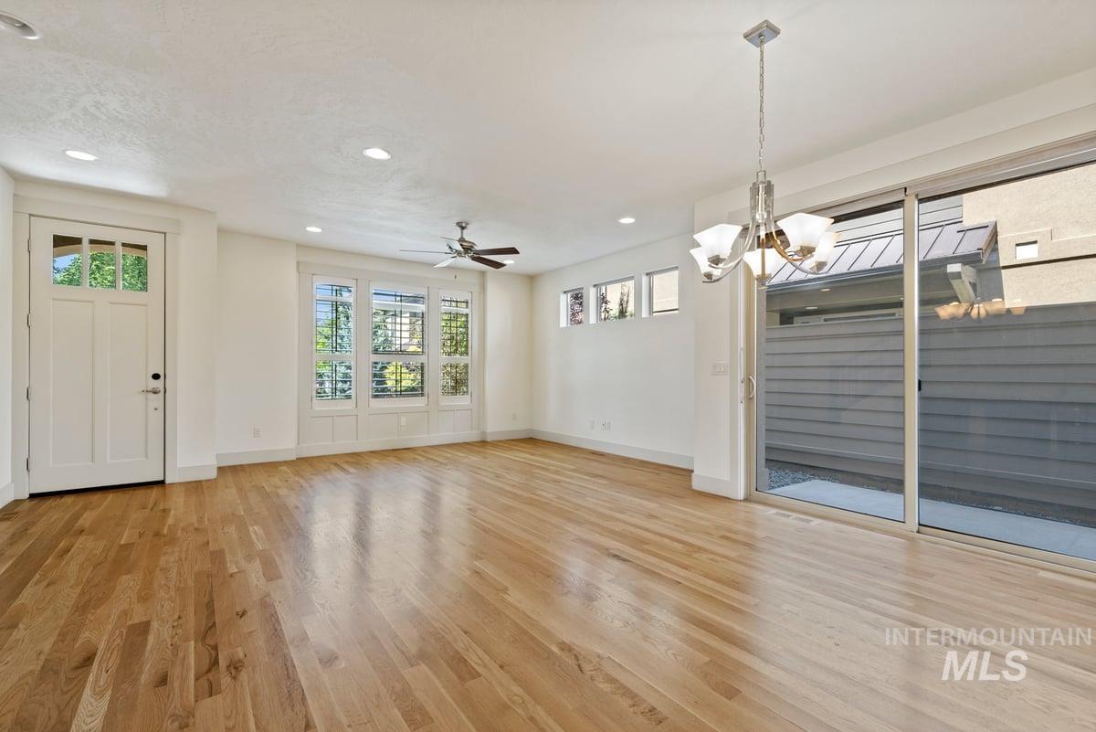 Unfurnished dining area with recessed lighting, light wood-style floors, a ceiling fan, and a chandelier