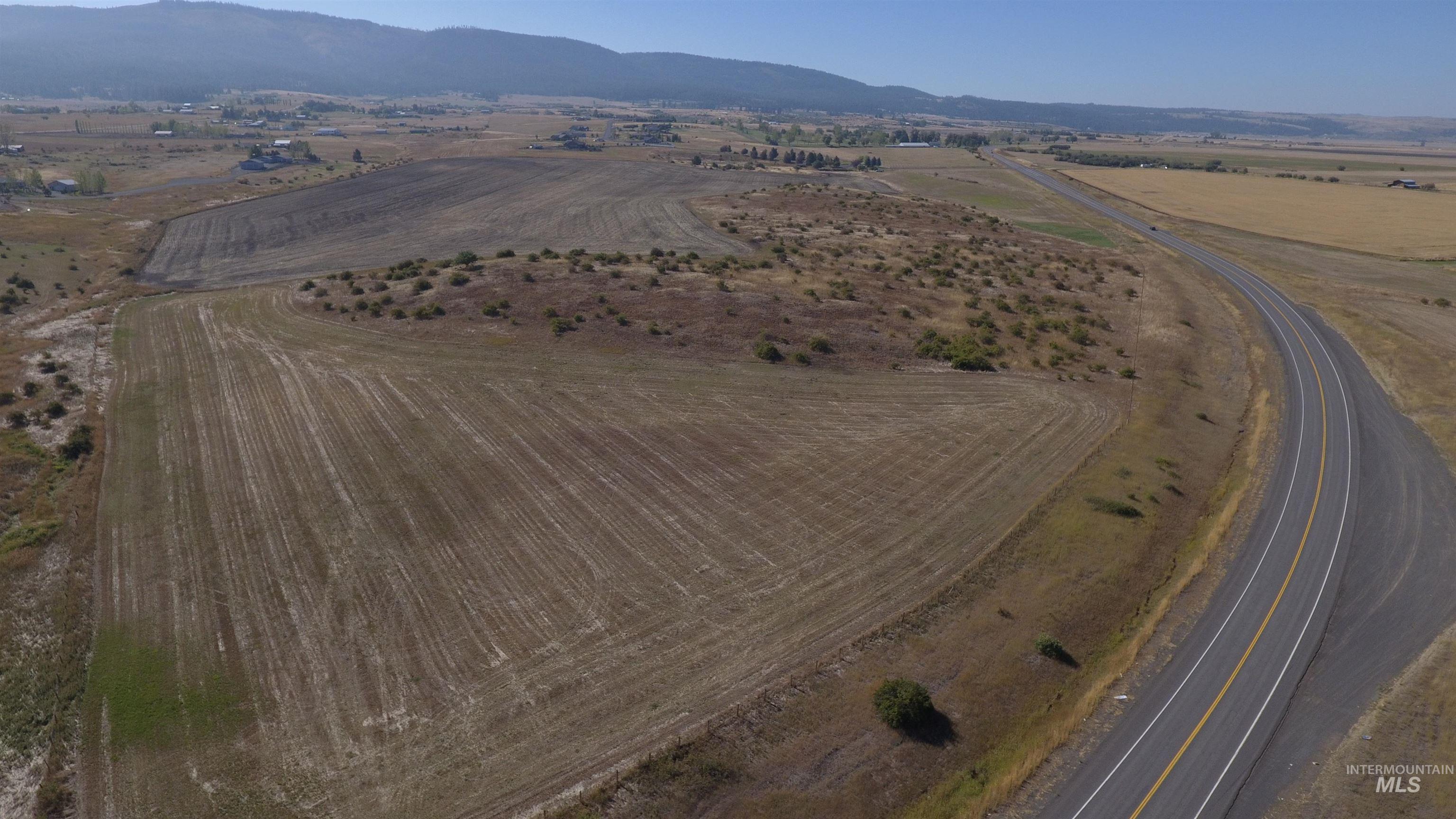 Aerial view of property and surrounding area with rural landscape and a mountainous background