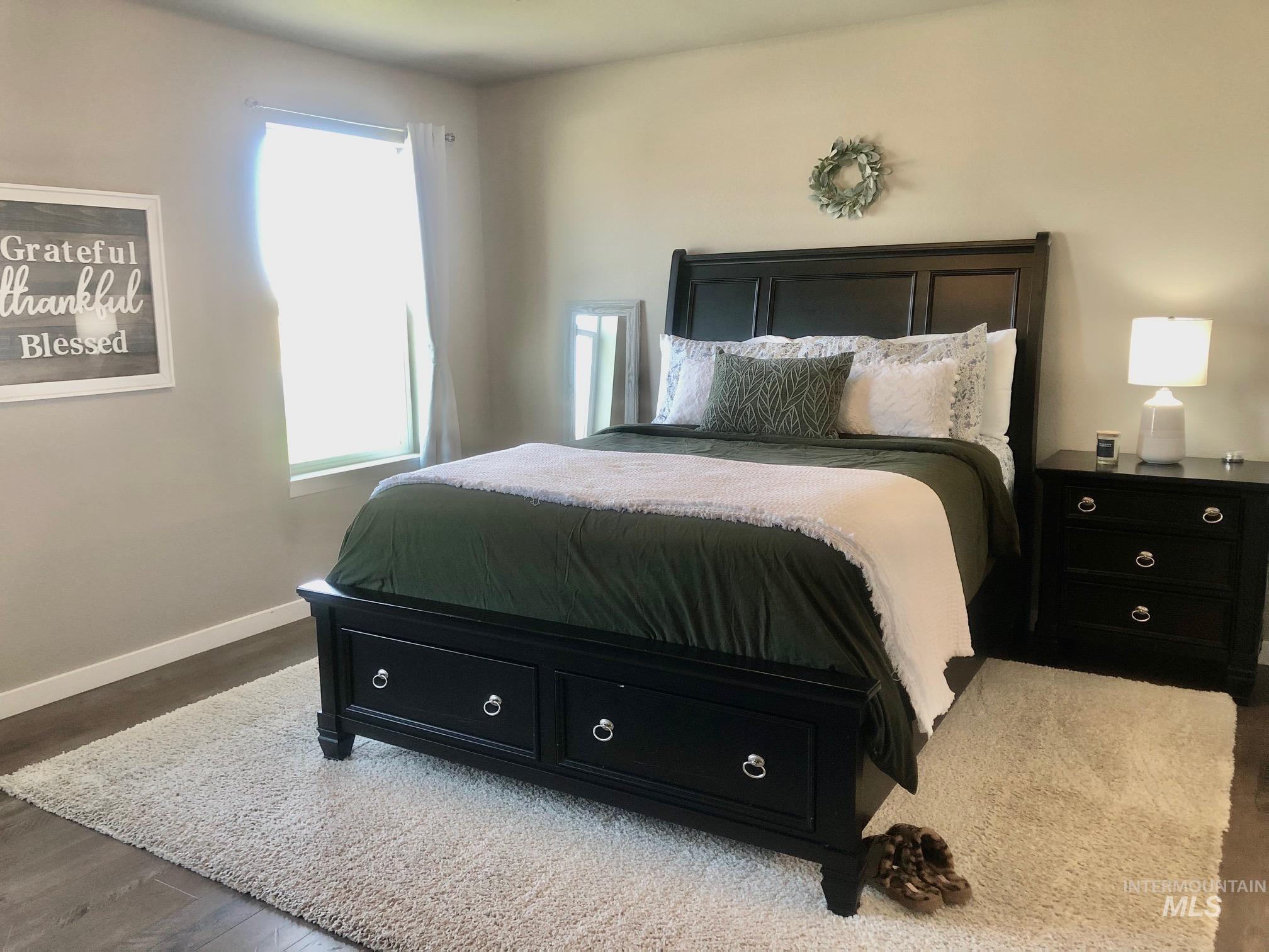 Bedroom featuring wood finished floors and baseboards