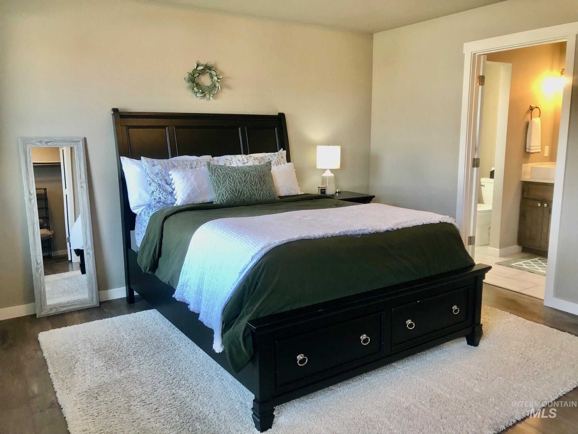 Bedroom featuring dark wood finished floors and ensuite bathroom