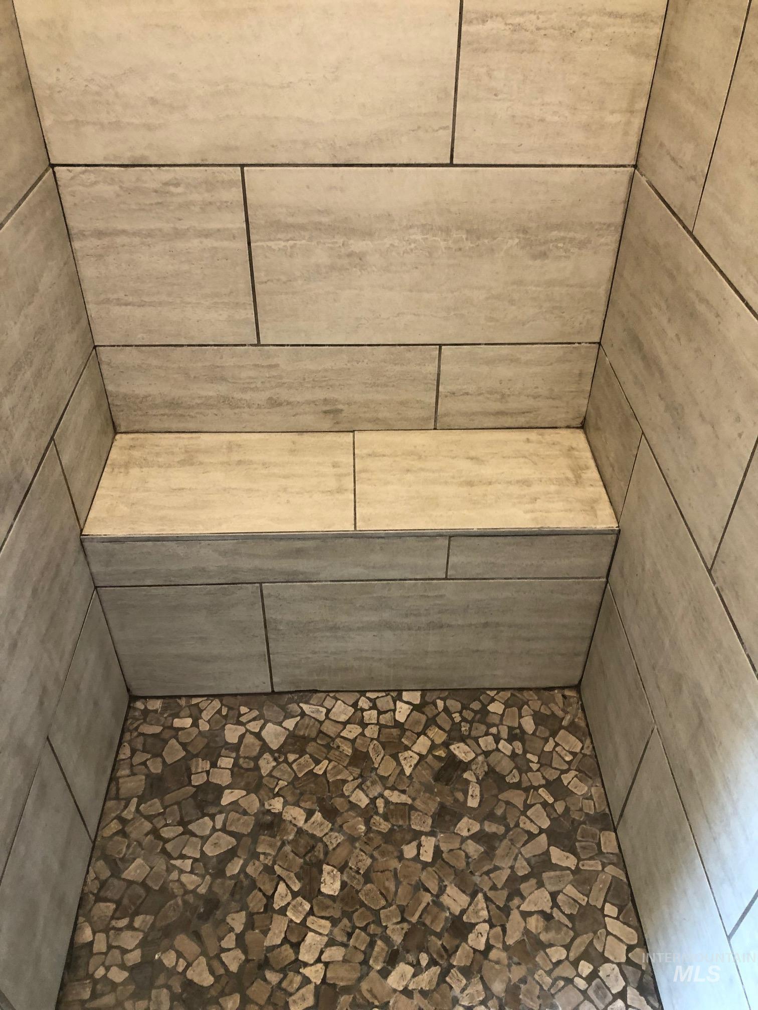 Bathroom view of a tile shower and a relaxing sauna