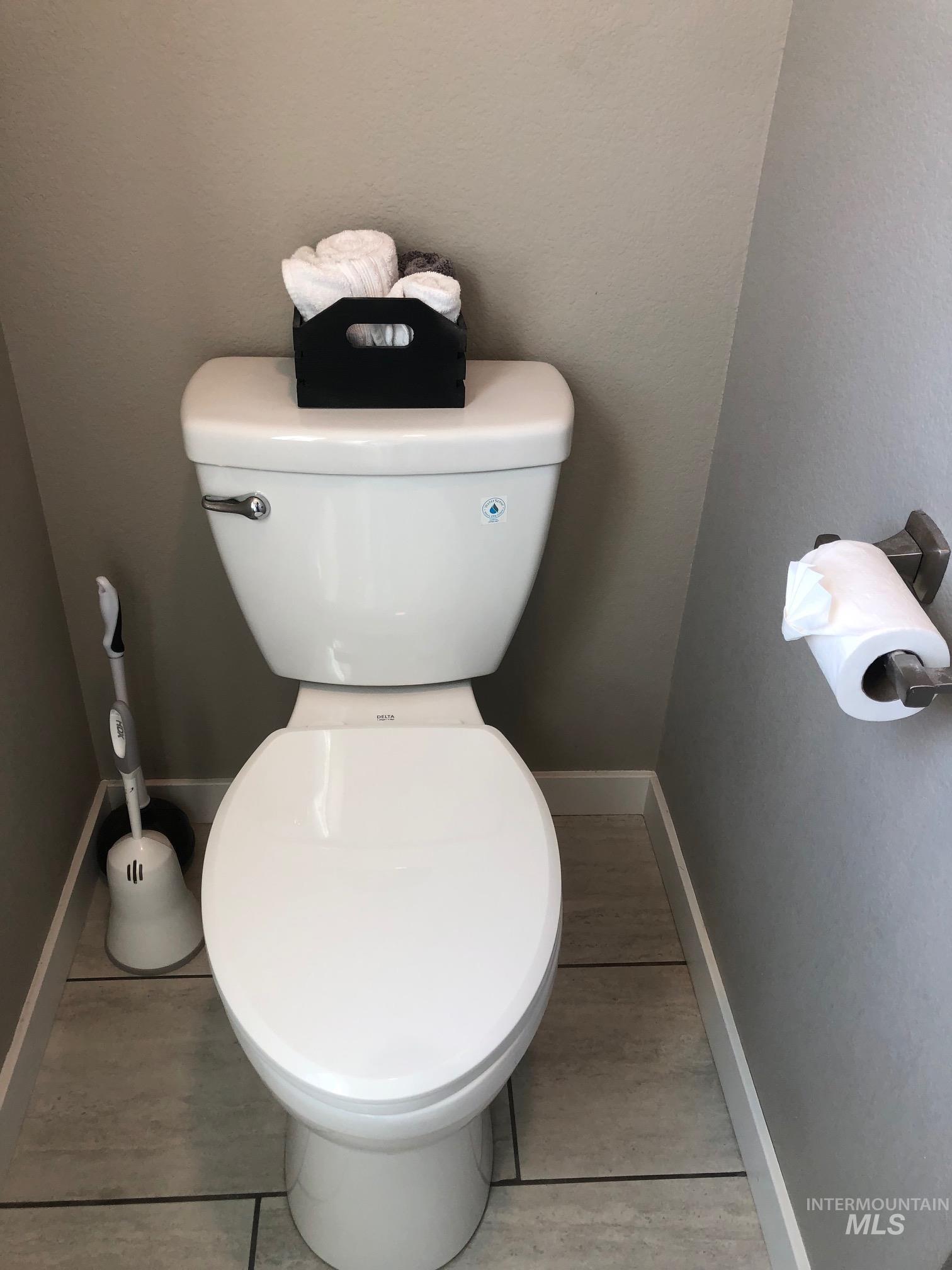 Bathroom featuring toilet and a textured wall