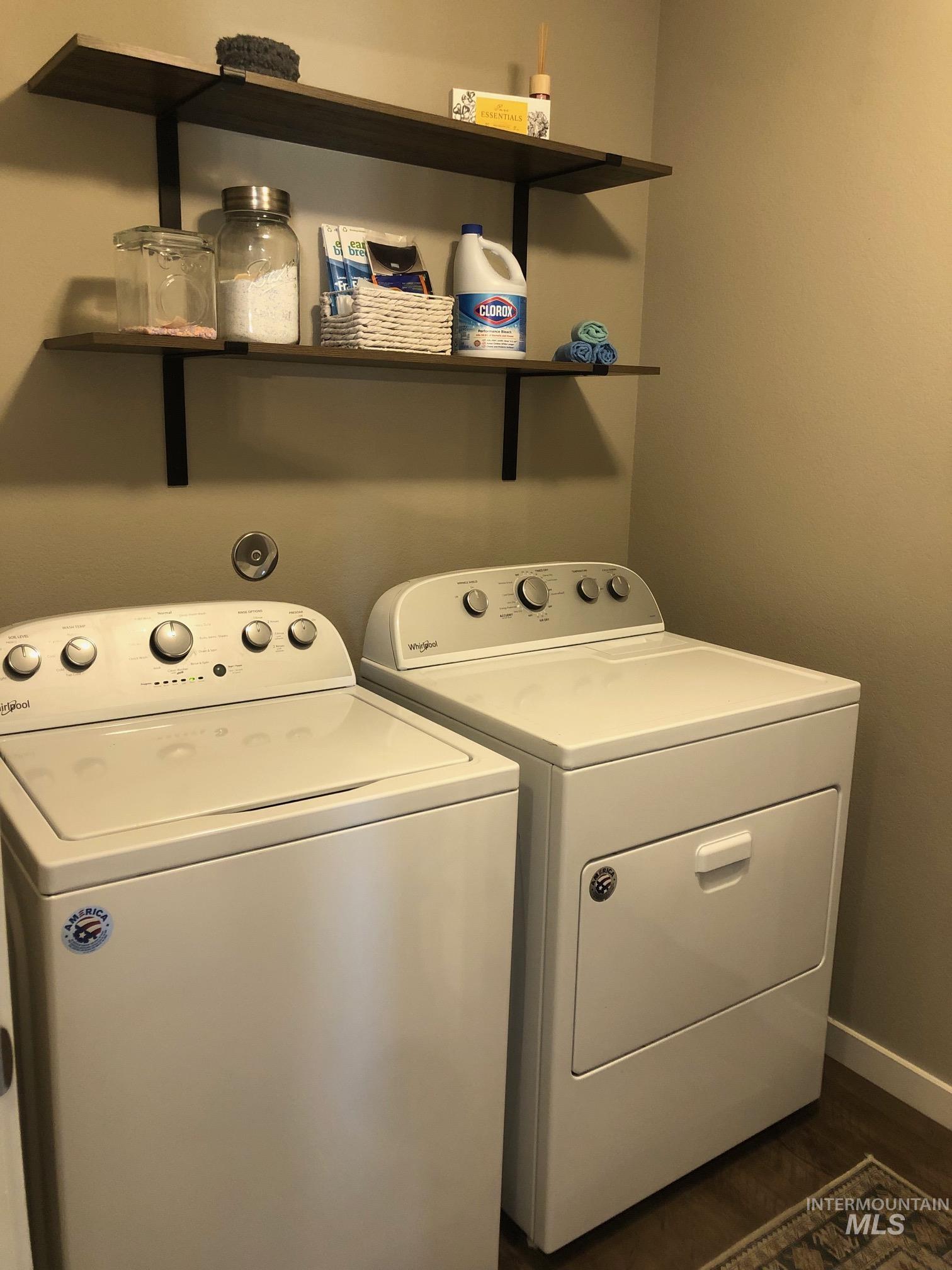 Laundry room featuring washer and dryer and dark wood-type flooring
