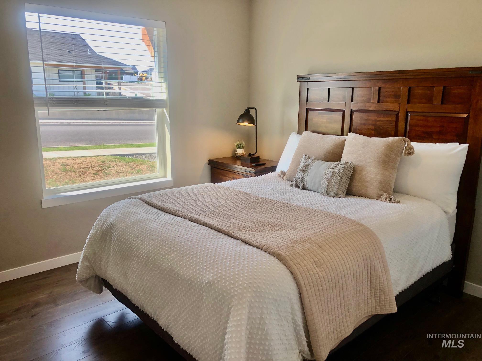Bedroom featuring baseboards and dark wood-style floors