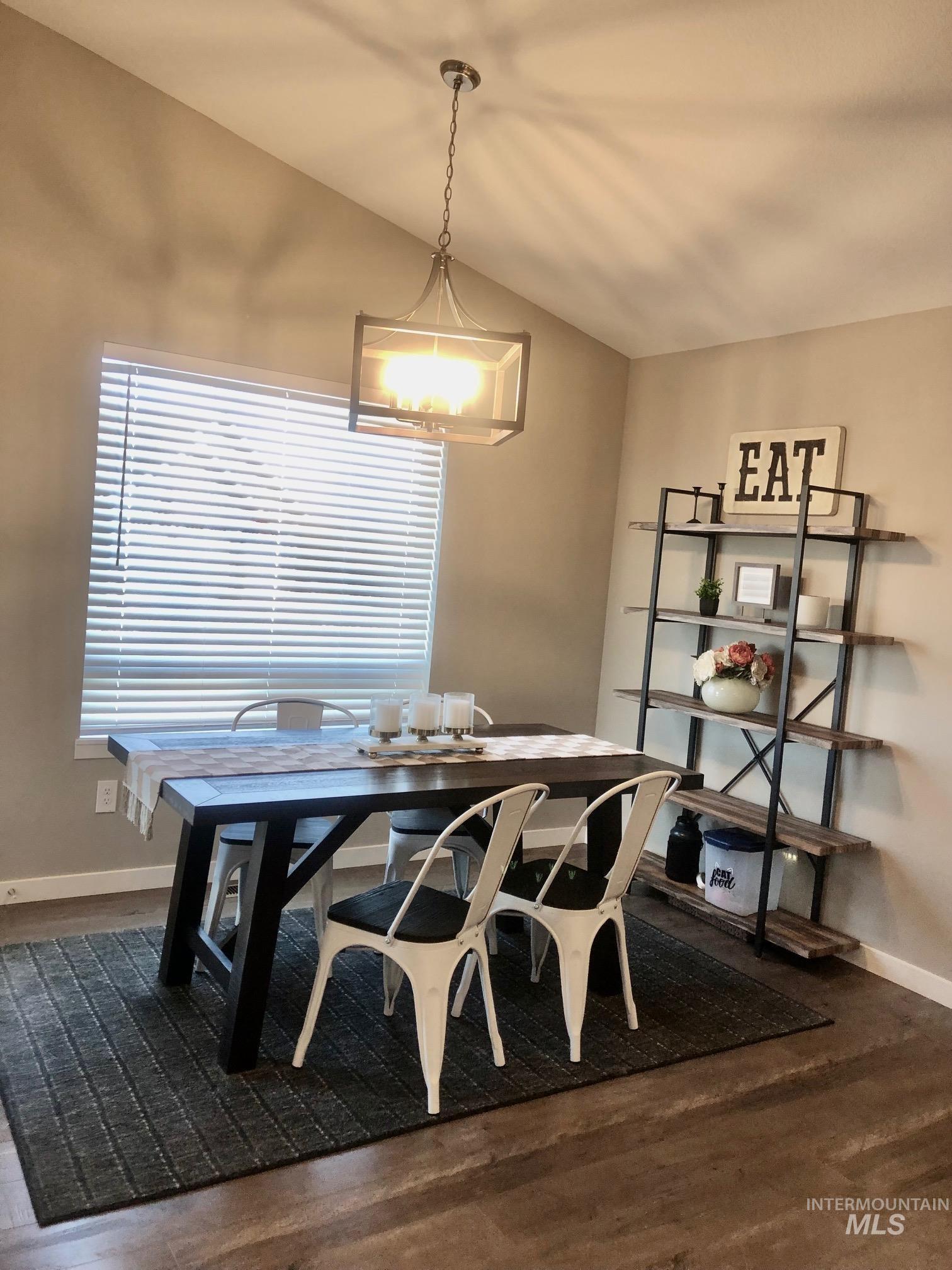 Dining area featuring baseboards and dark wood-style flooring