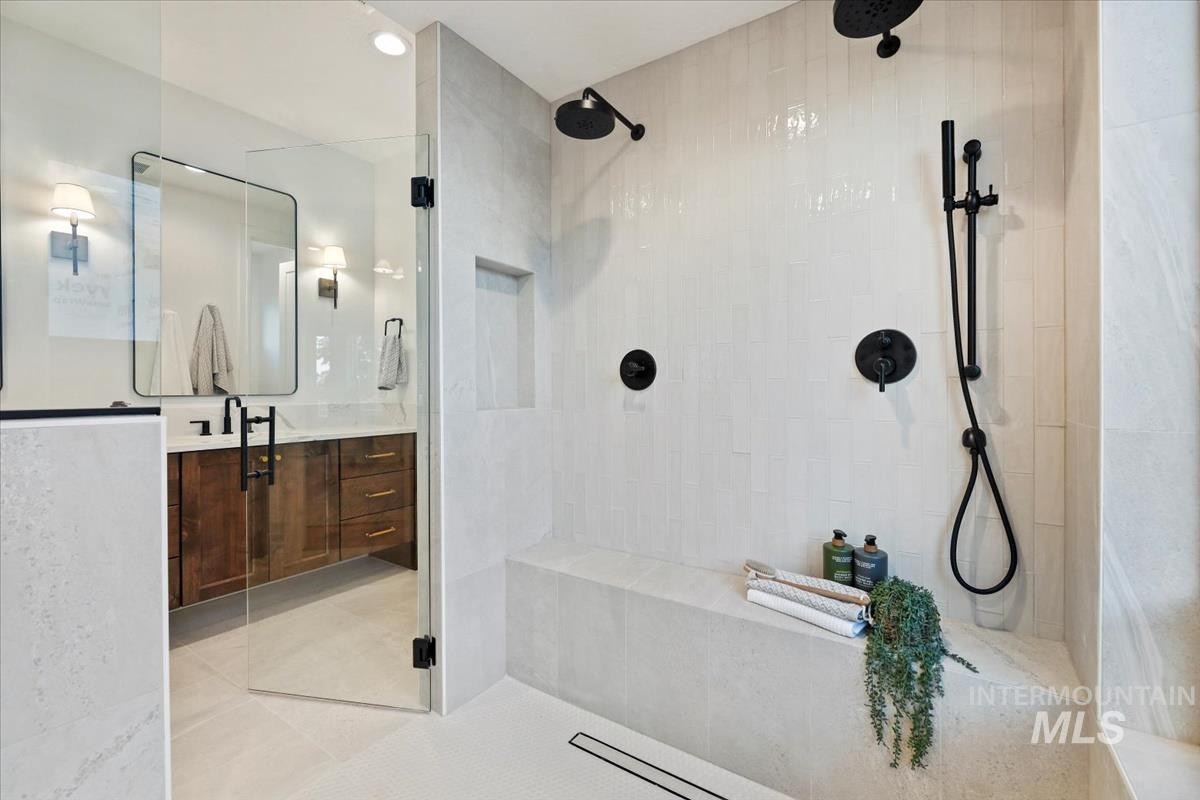 Bathroom featuring vanity, a shower stall, light tile patterned floors, and recessed lighting