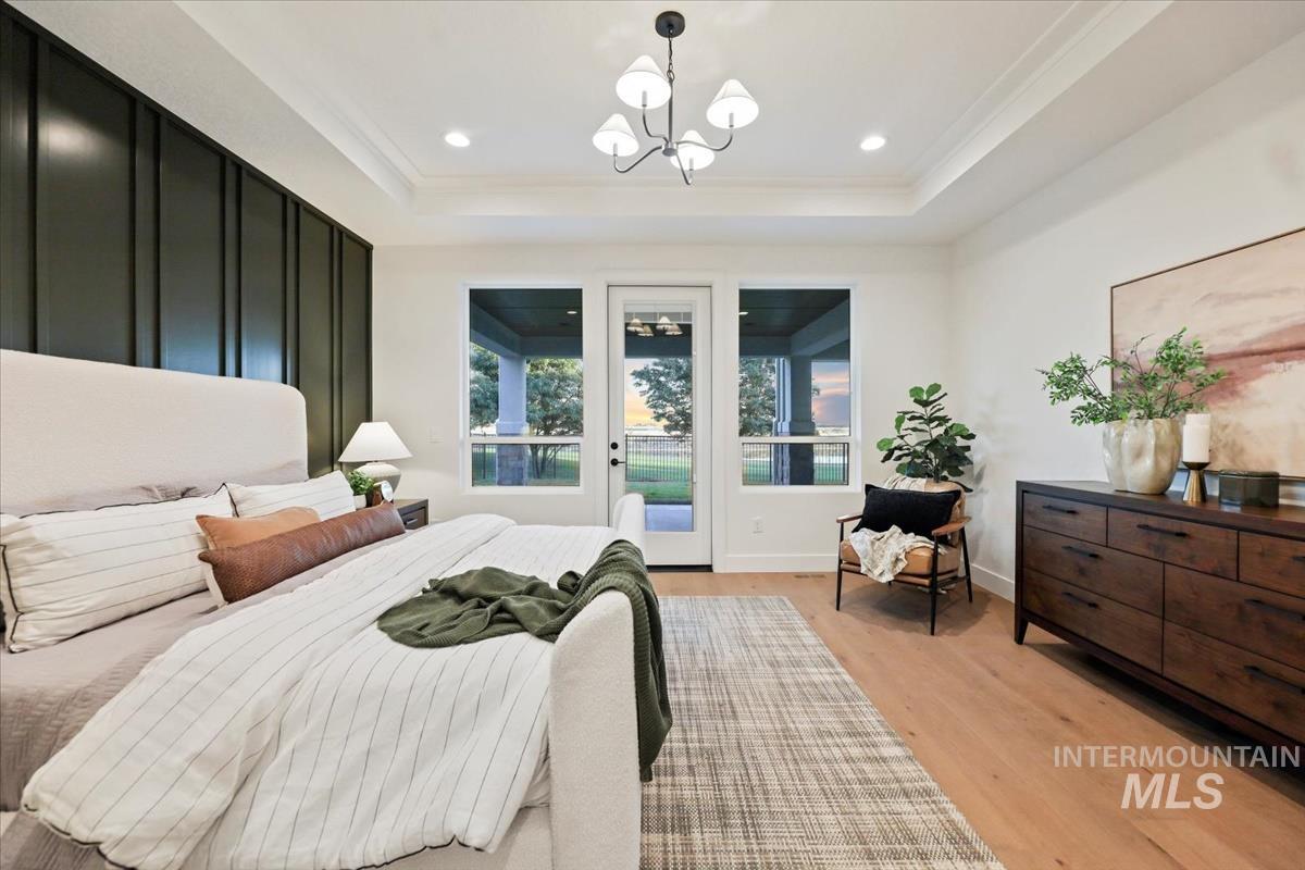 Bedroom with light wood finished floors, crown molding, recessed lighting, access to outside, and a chandelier