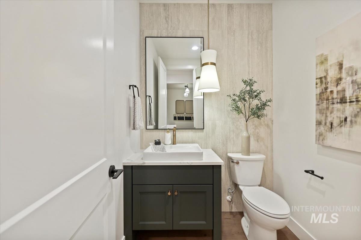 Half bathroom with vanity and wood finished floors