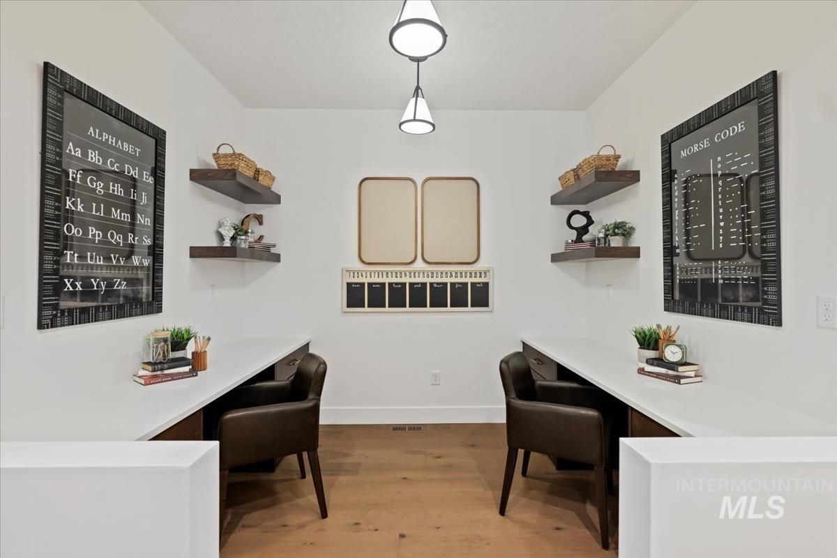 Office area with light wood-style floors and built in desk
