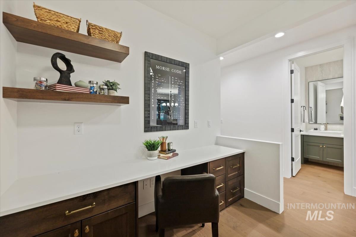 Office area with built in study area, light wood-style flooring, and recessed lighting