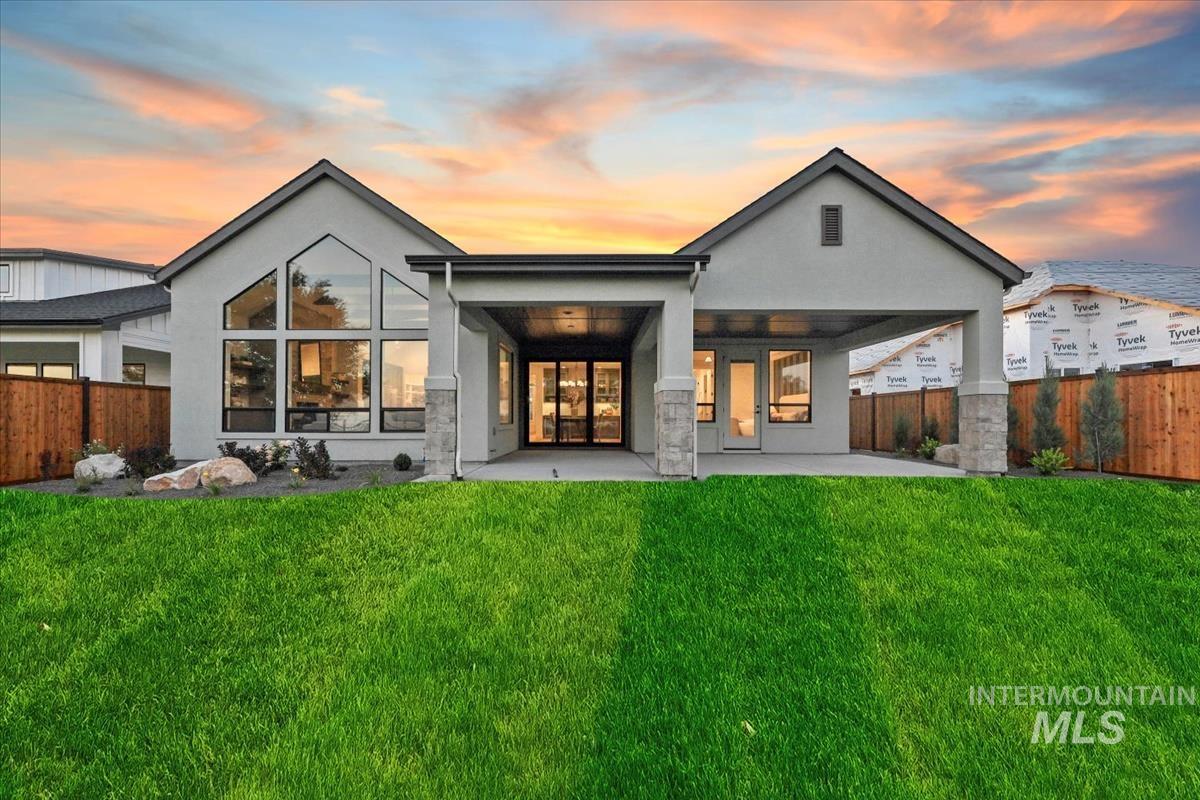 Back of property at dusk with a patio and stucco siding