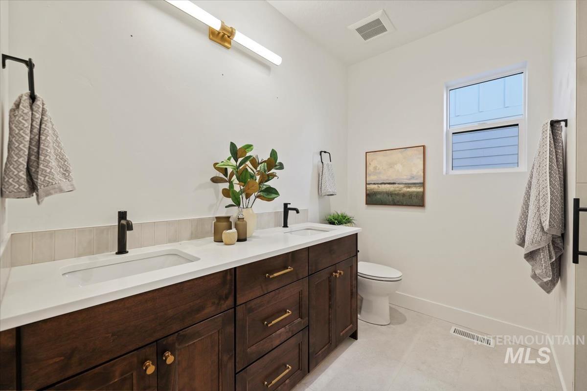 Full bathroom with double vanity and light tile patterned floors