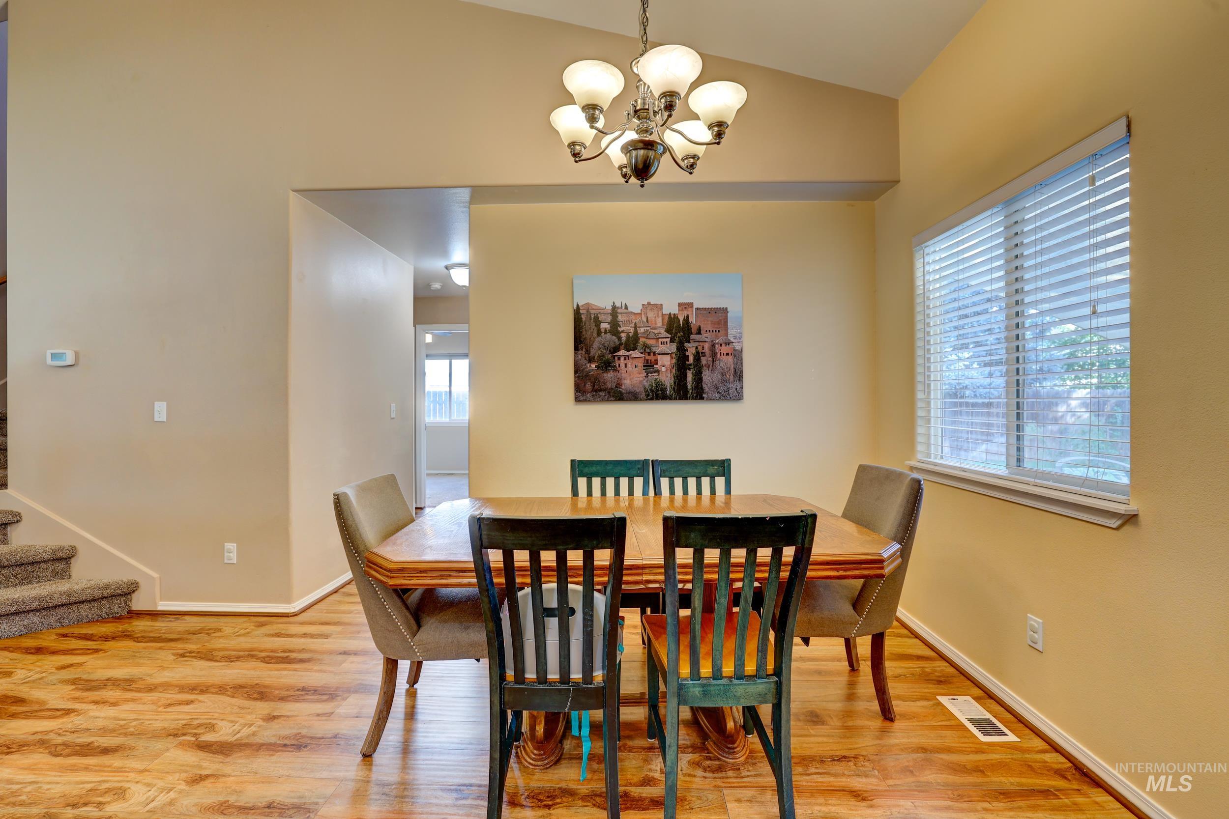 Dining room featuring light wood-style flooring, stairway, and a chandelier