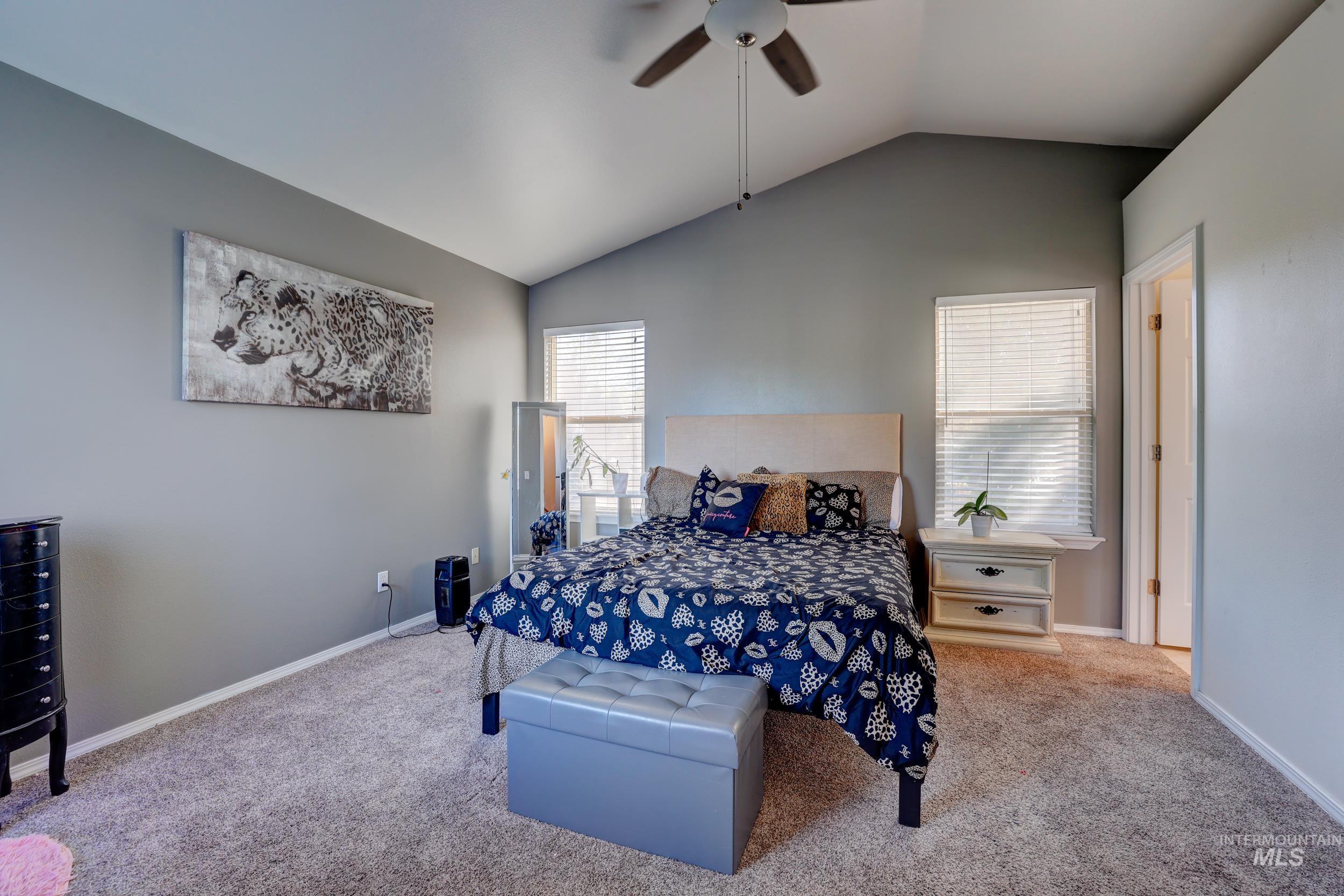 Bedroom featuring vaulted ceiling, carpet, and ceiling fan