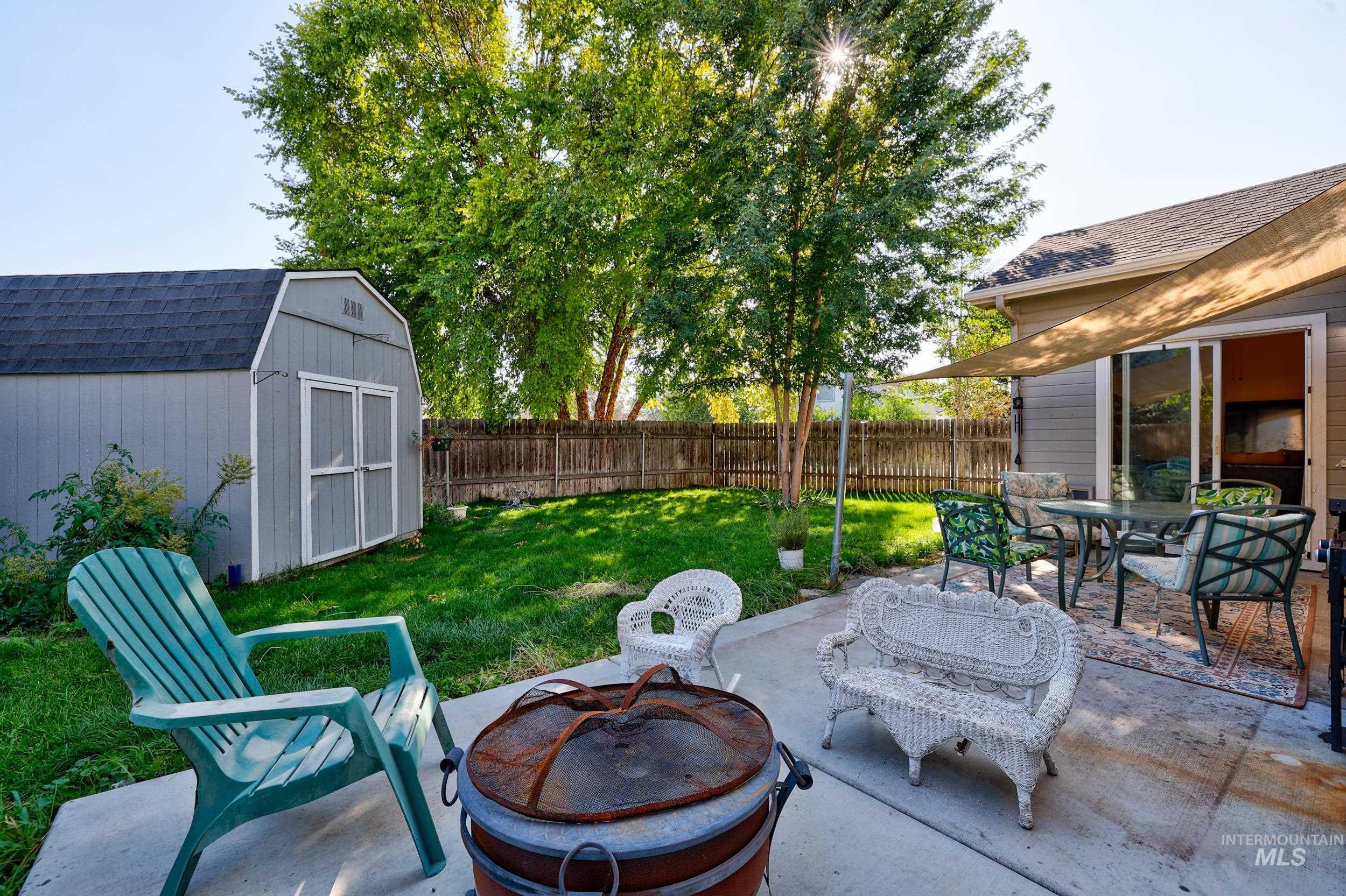 View of patio with a fire pit, a storage unit, and outdoor dining space