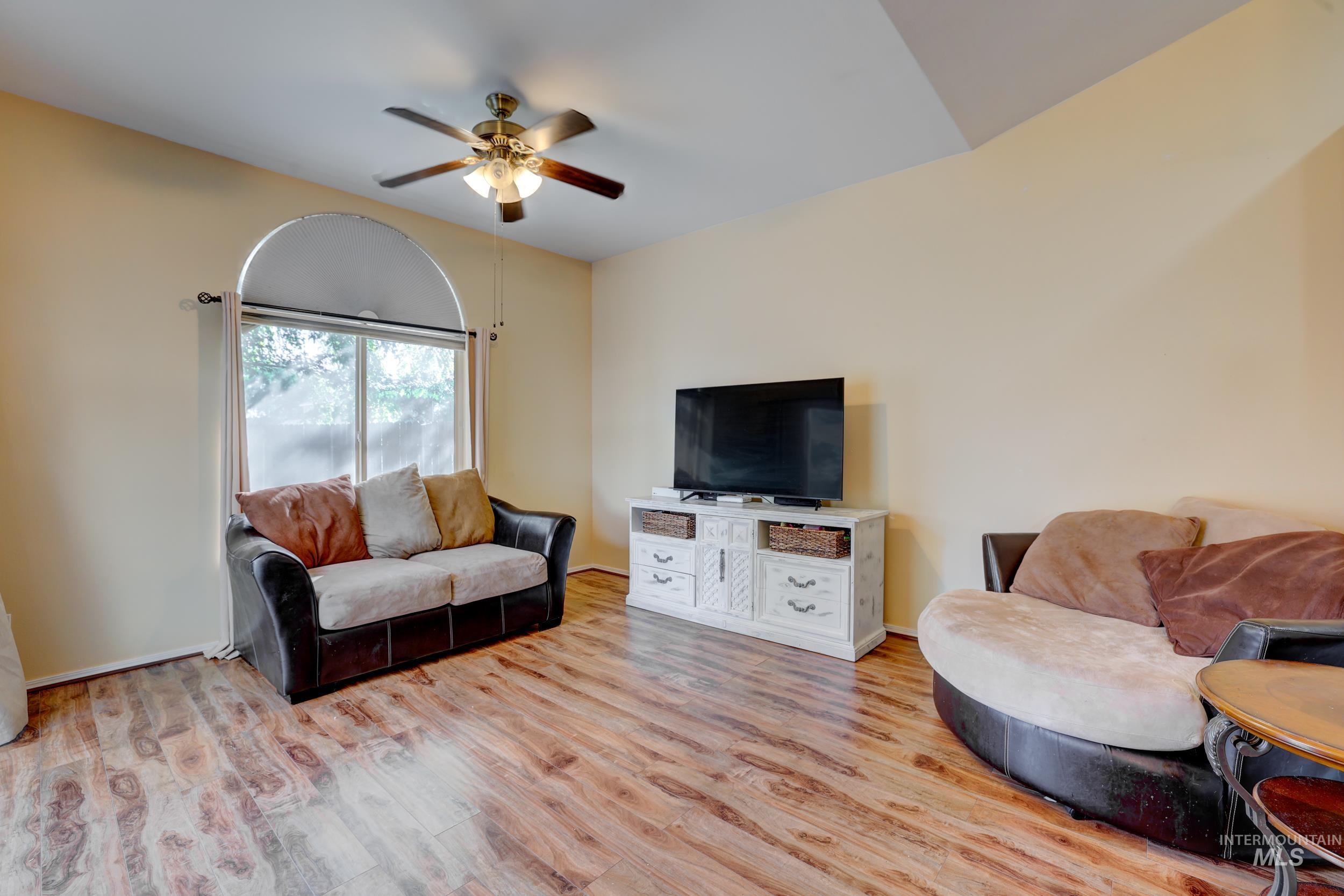 Living area with light wood-style flooring and a ceiling fan