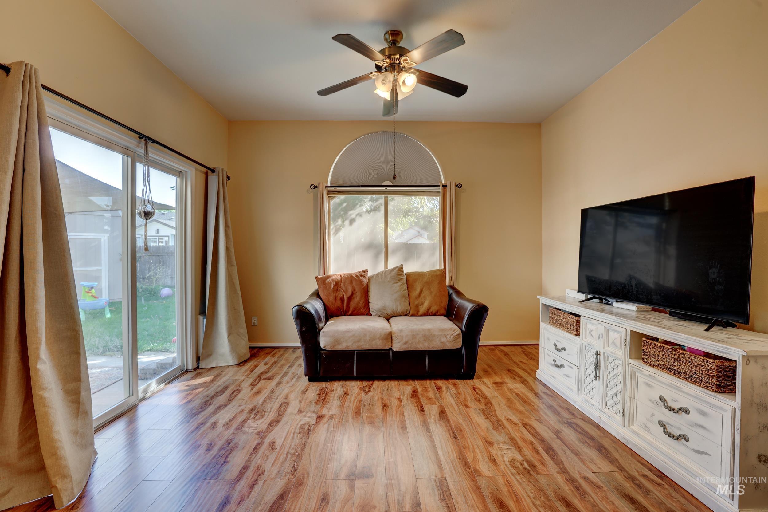 Living room featuring light wood finished floors and a ceiling fan