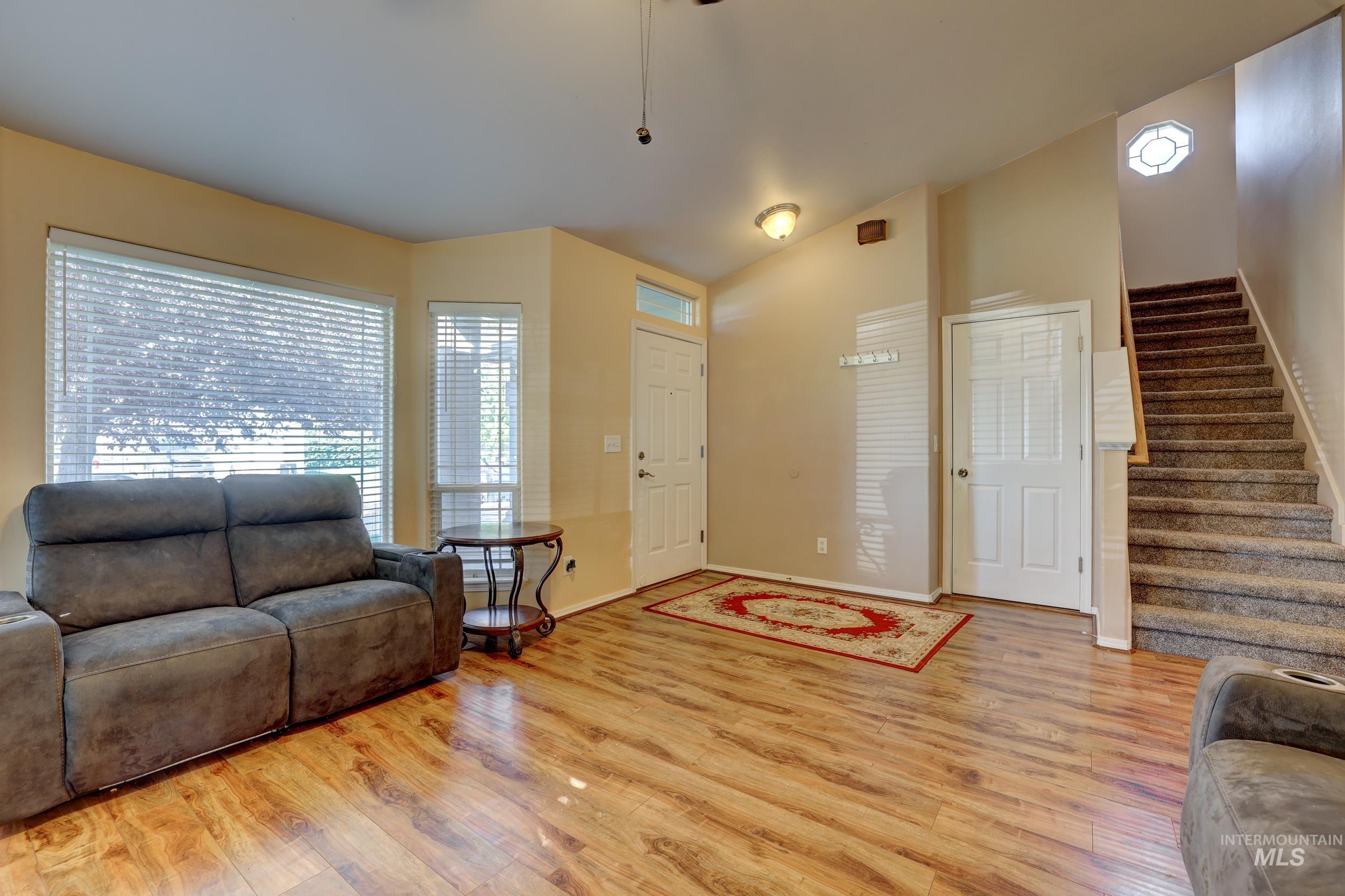 Living area with stairway, light wood-type flooring, and ceiling fan