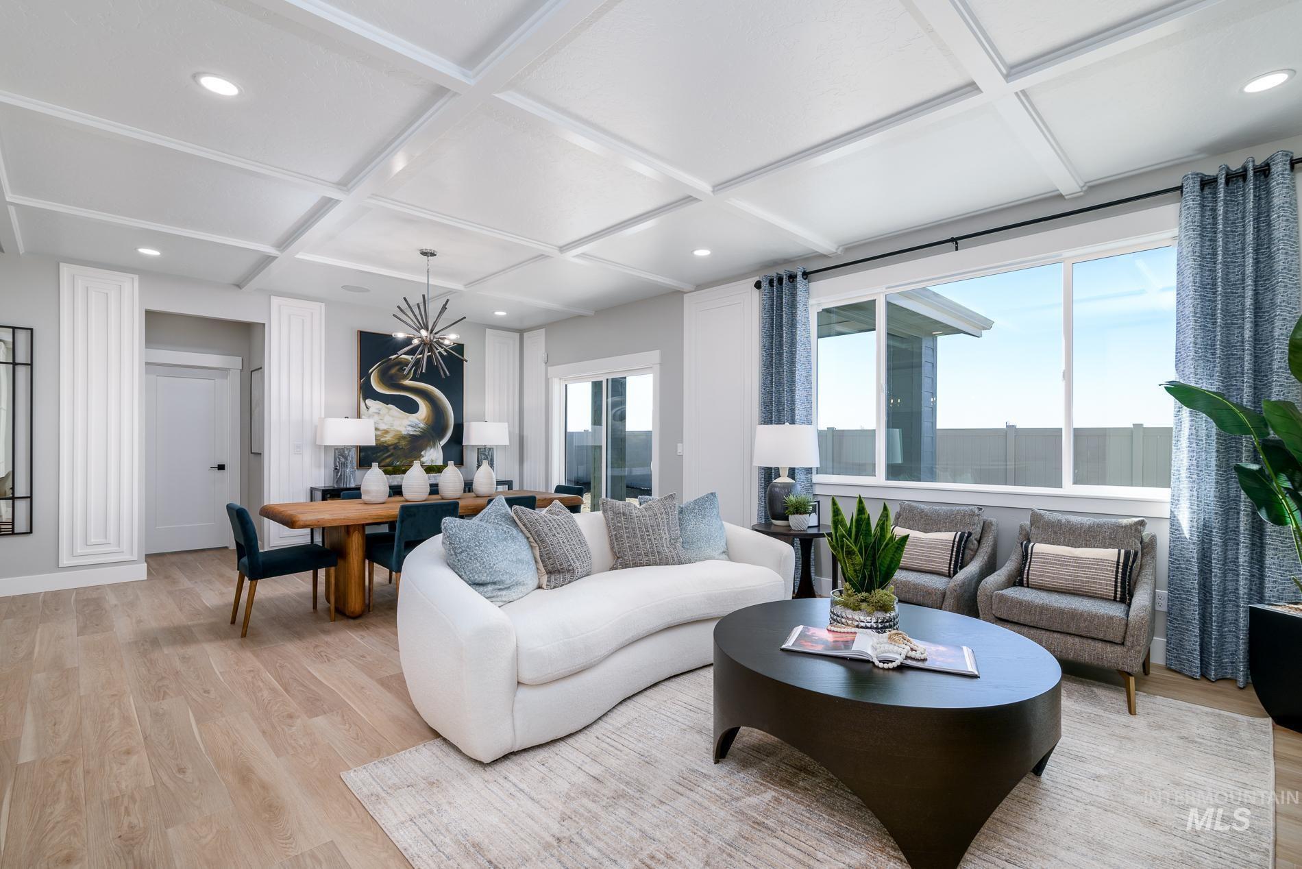 Living area with light wood finished floors, coffered ceiling, beam ceiling, and recessed lighting