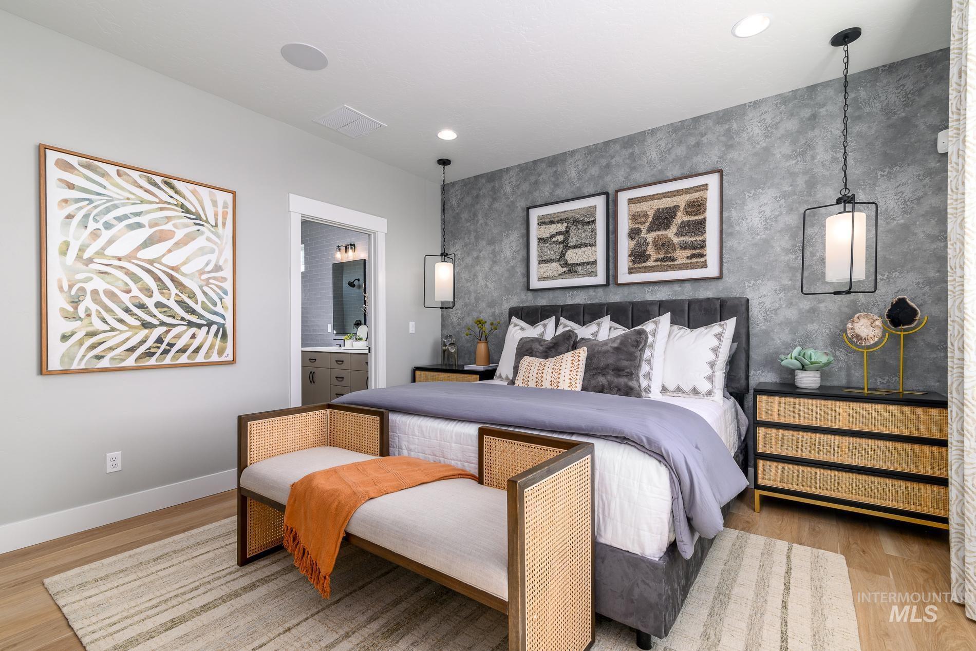 Bedroom featuring light wood-type flooring, an accent wall, ensuite bathroom, recessed lighting, and wallpapered walls
