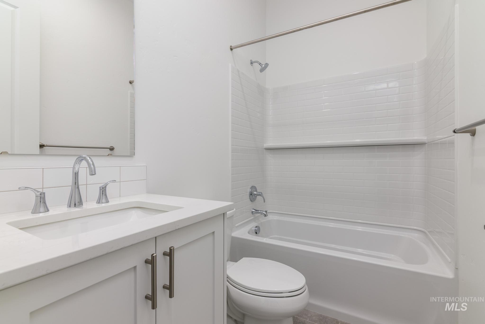 Full bath with shower / bath combination, vanity, and backsplash