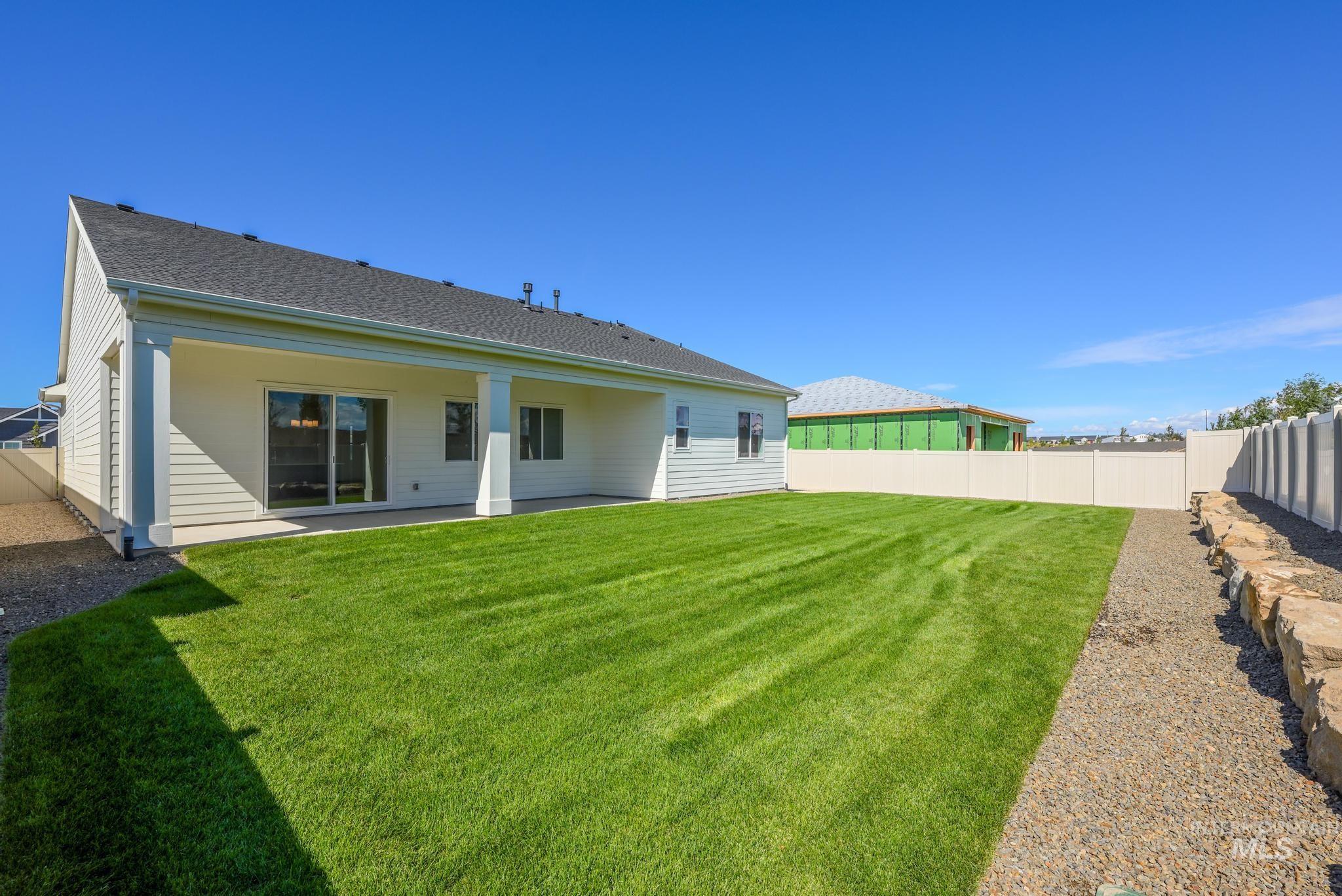 Back of house with a fenced backyard, a patio, and a shingled roof
