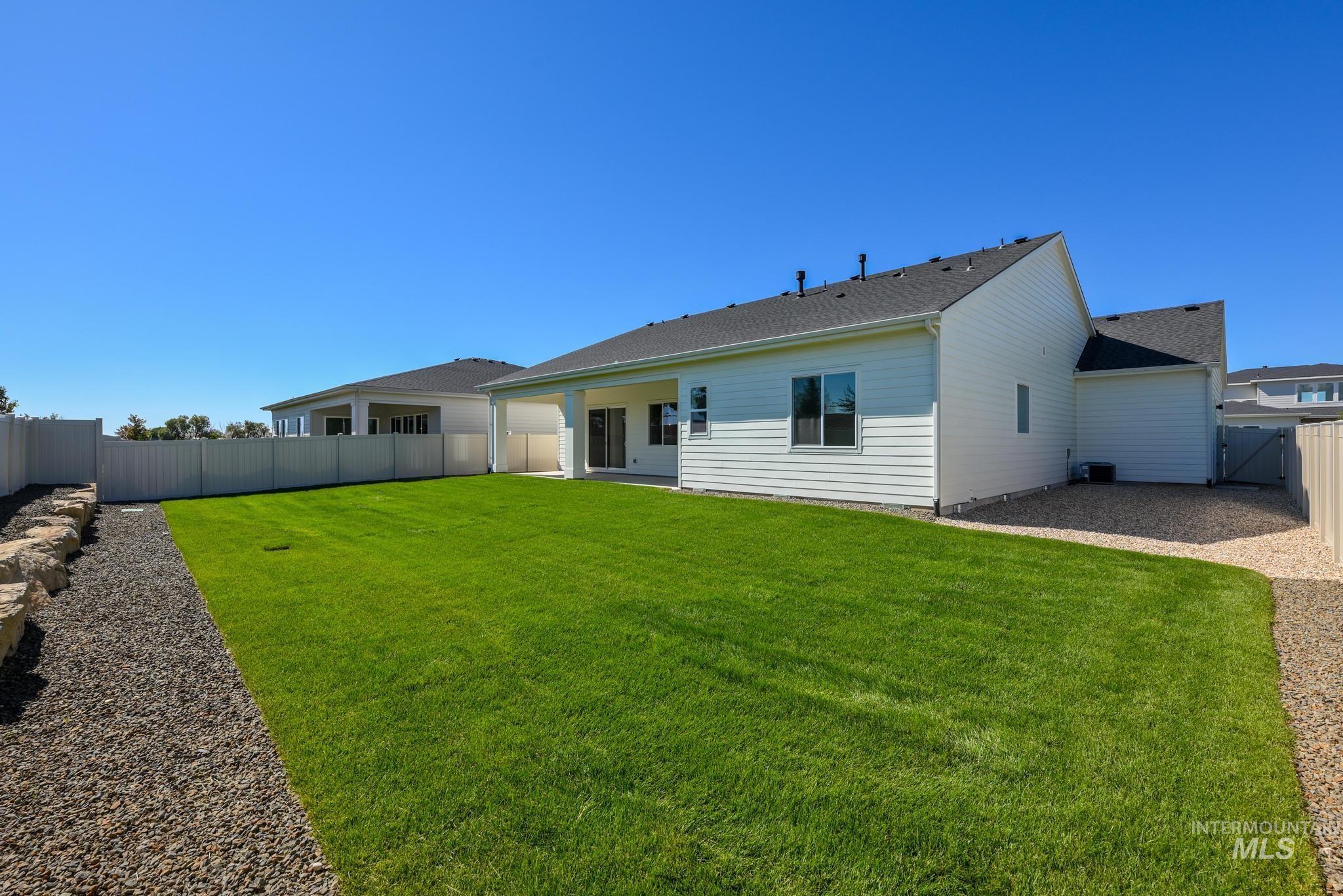 Back of property with a patio area, a fenced backyard, and roof with shingles