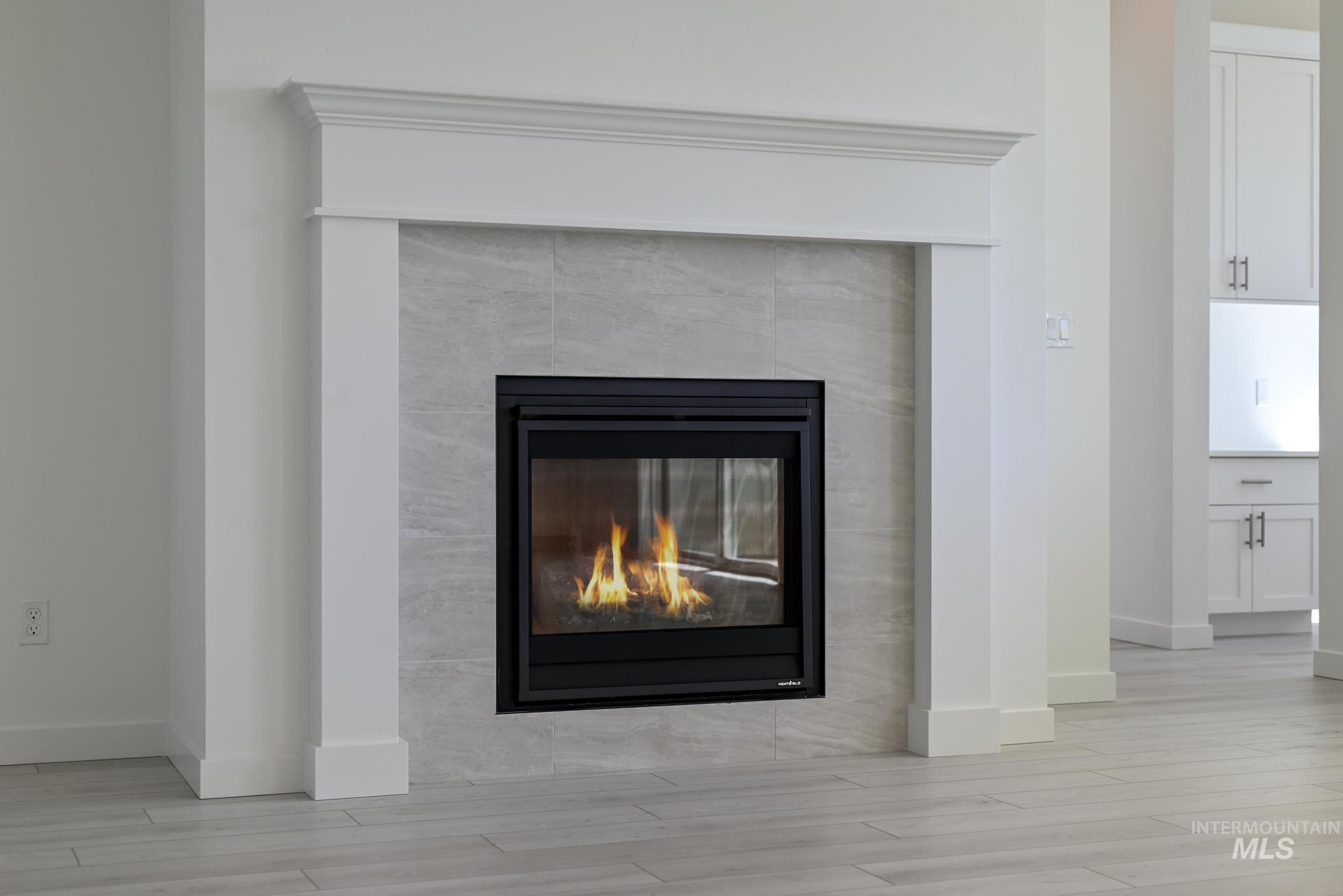 Detailed view of wood finished floors and a fireplace