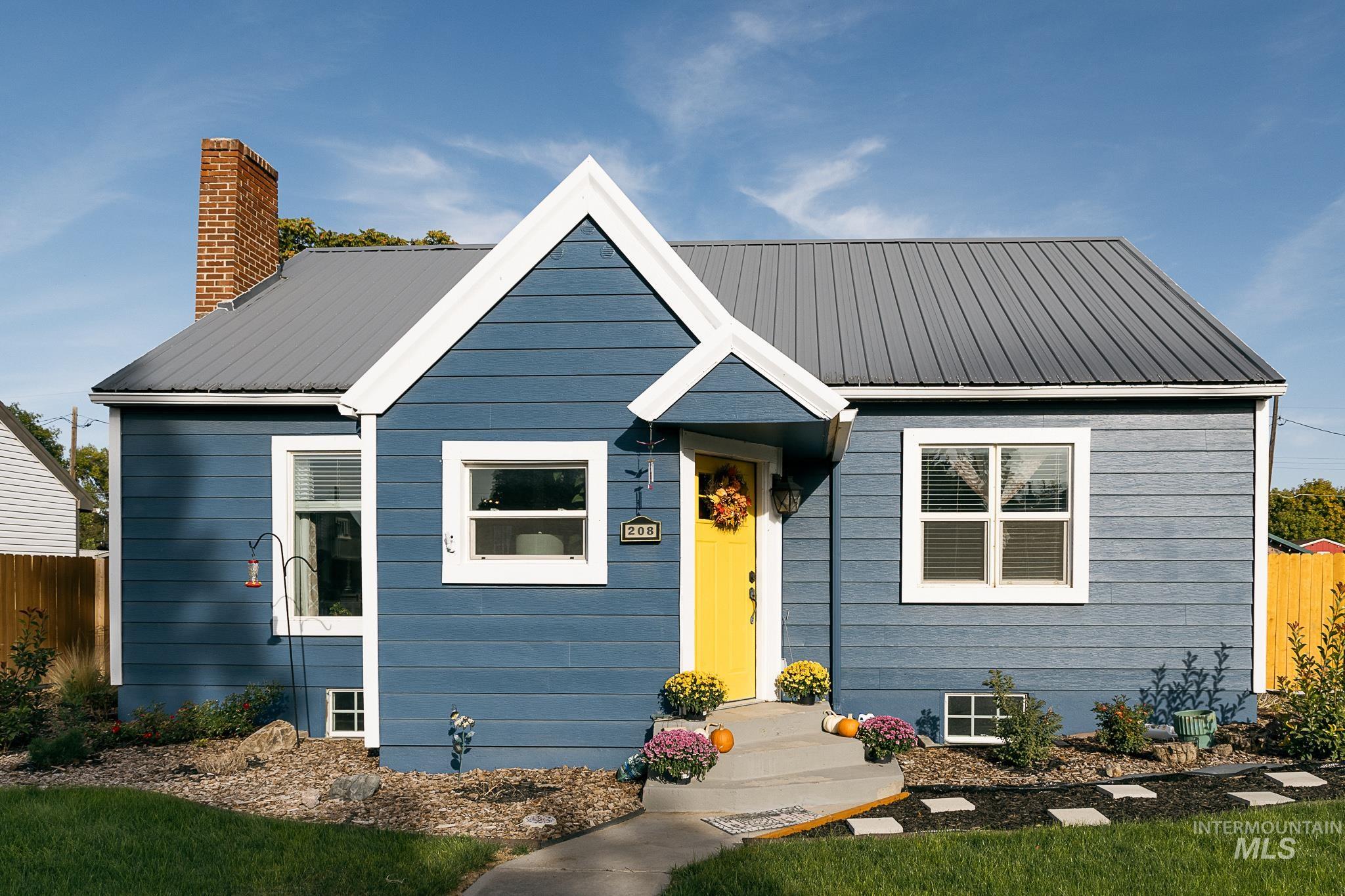 Bungalow with a metal roof and a chimney