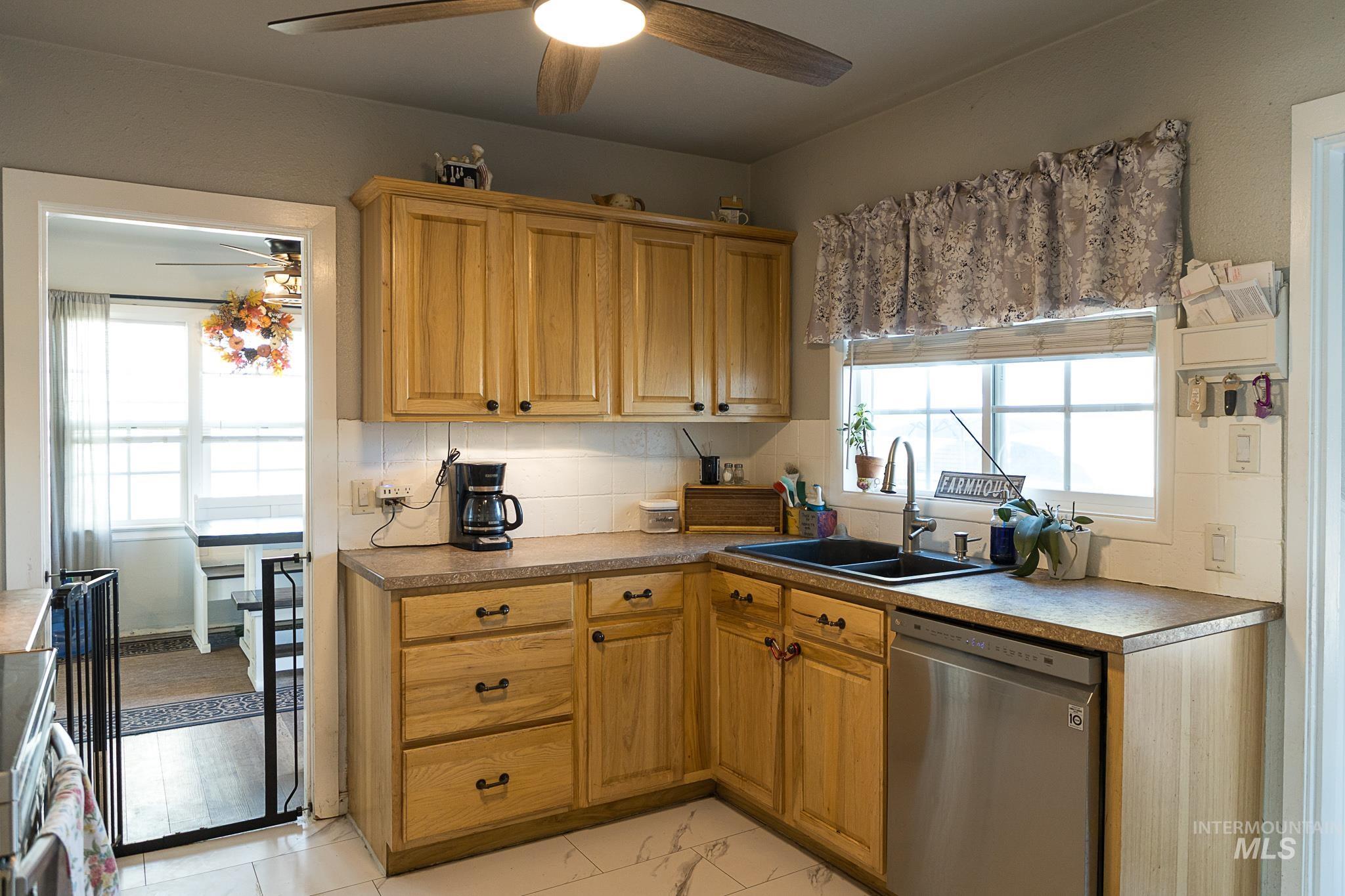 Kitchen featuring stainless steel appliances, a ceiling fan, and tasteful backsplash